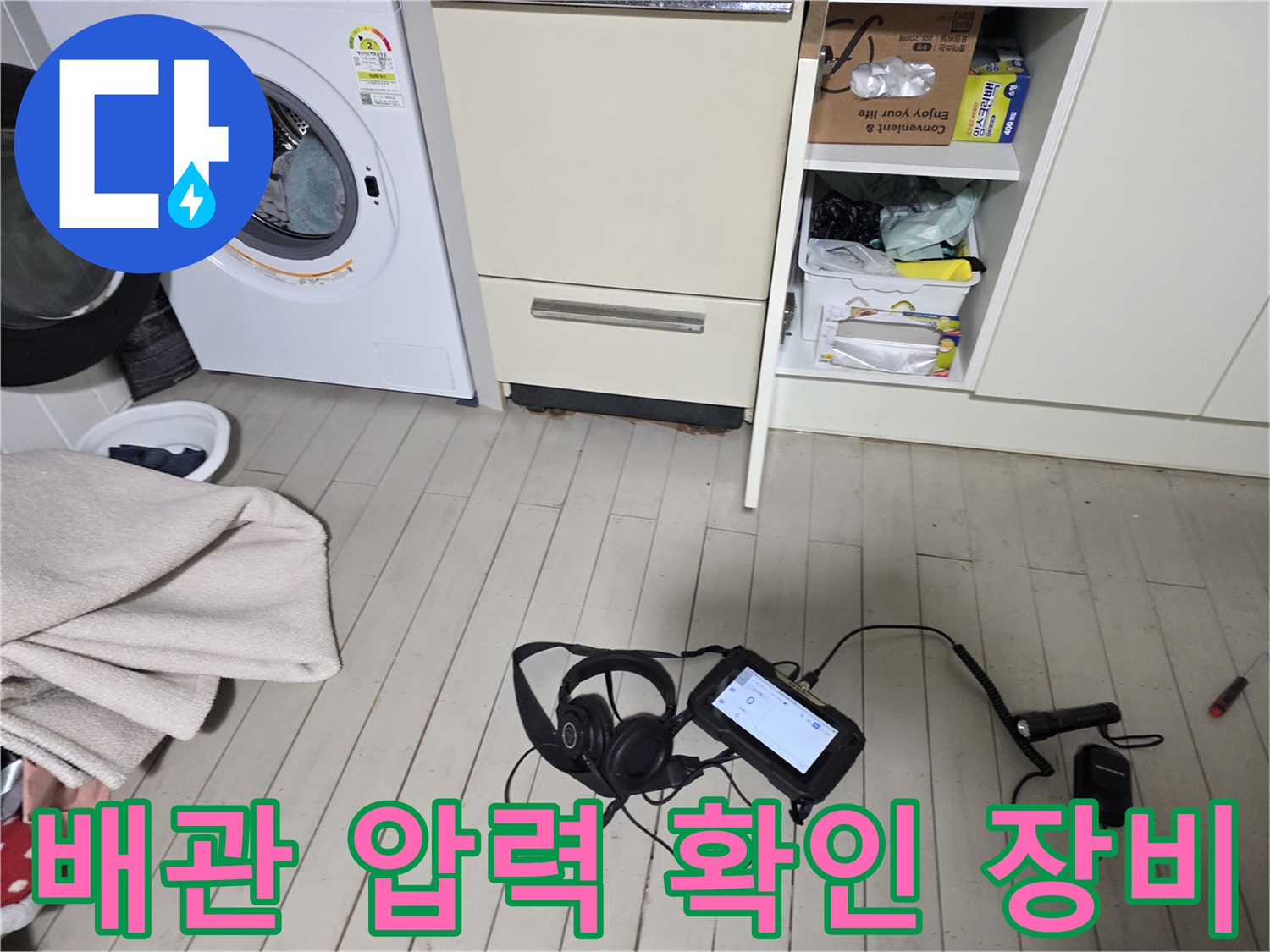 세탁기와 수납장 사이 바닥에 놓인 누수 탐지 전문 기기