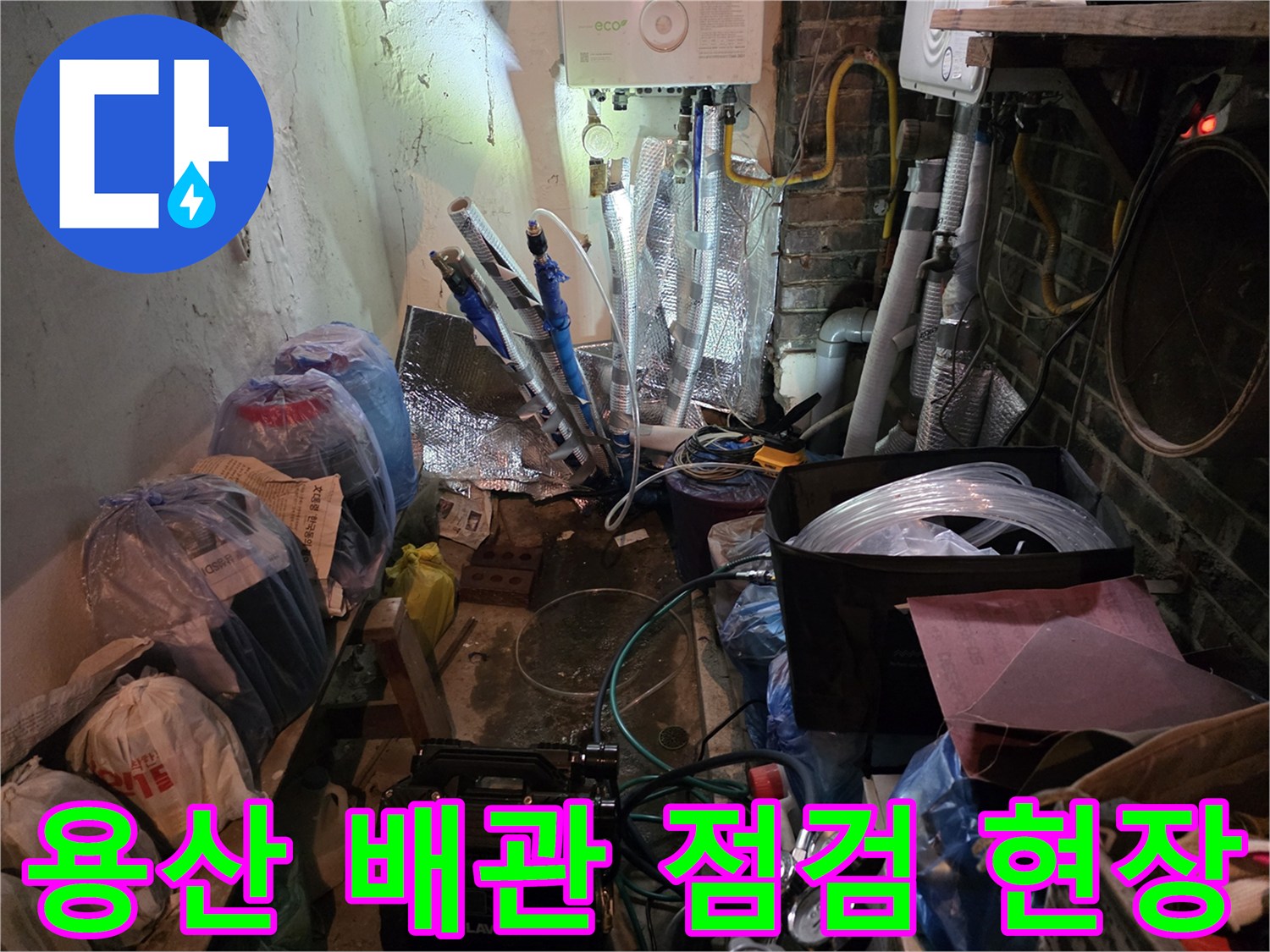 용산구 주방 하부장 아래 복잡하게 얽힌 배관과 설비 장비들