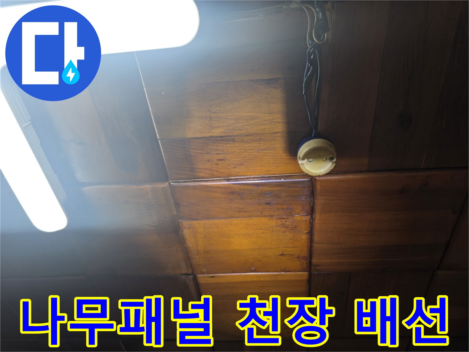 전등 근처 노출된 전선과 나무 천장 마감재 상세 사진