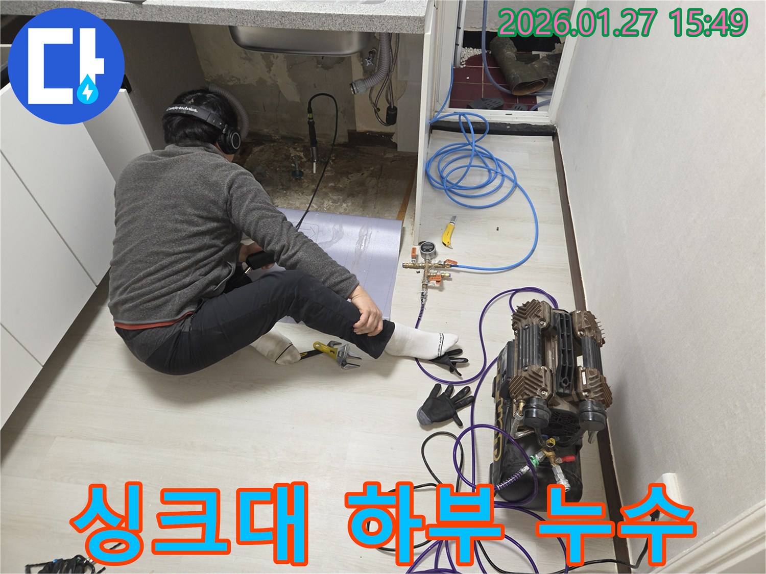 수원 영통구 싱크대 하부에서 누수 탐지 작업을 진행 중인 전문가의 모습-다양한 장비를 활용하여 정확한 원인을 파악합니다.