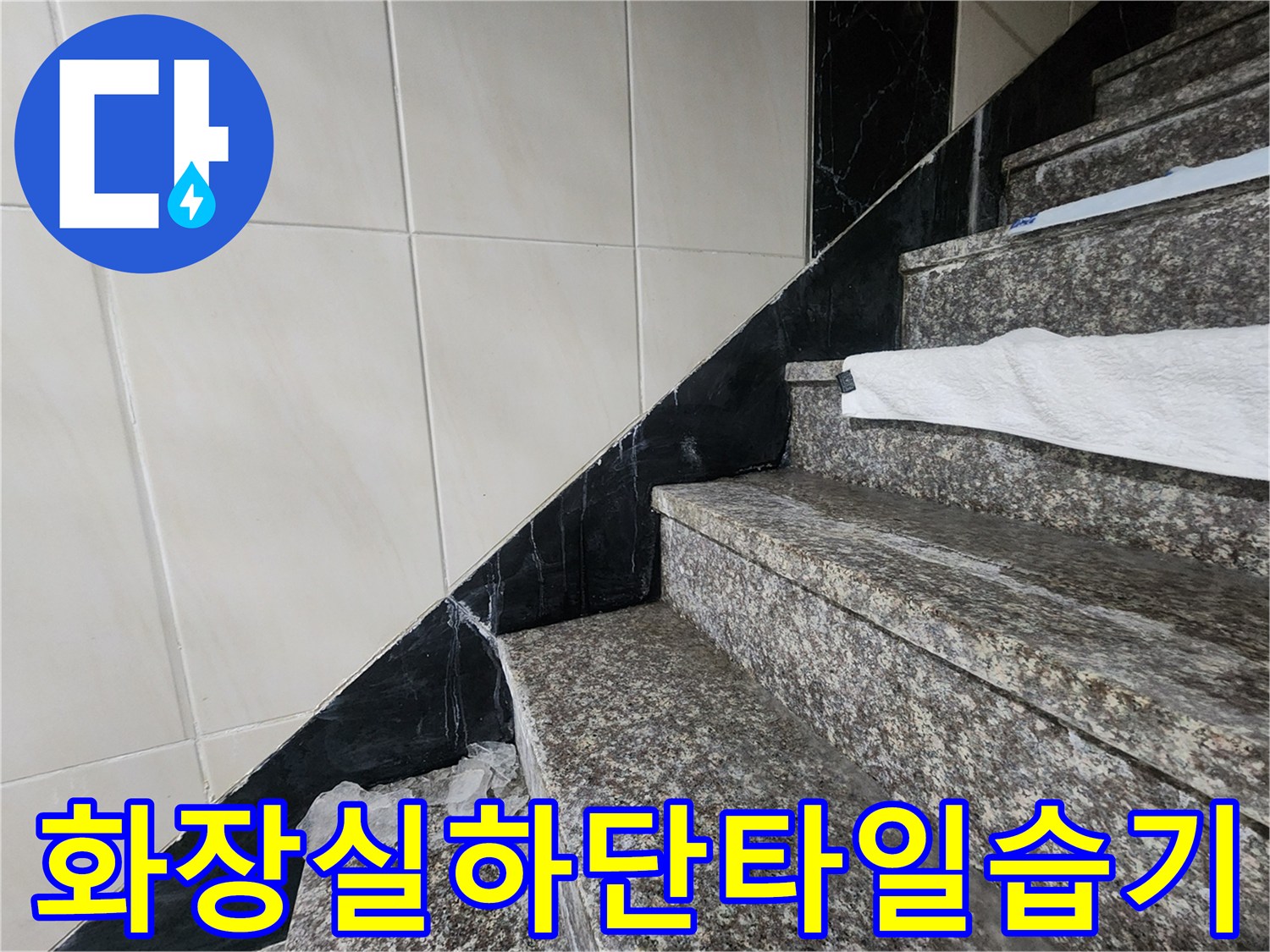 흰색 타일과 검은색 석재 경계에 나타난 습기 및 변색 부위
