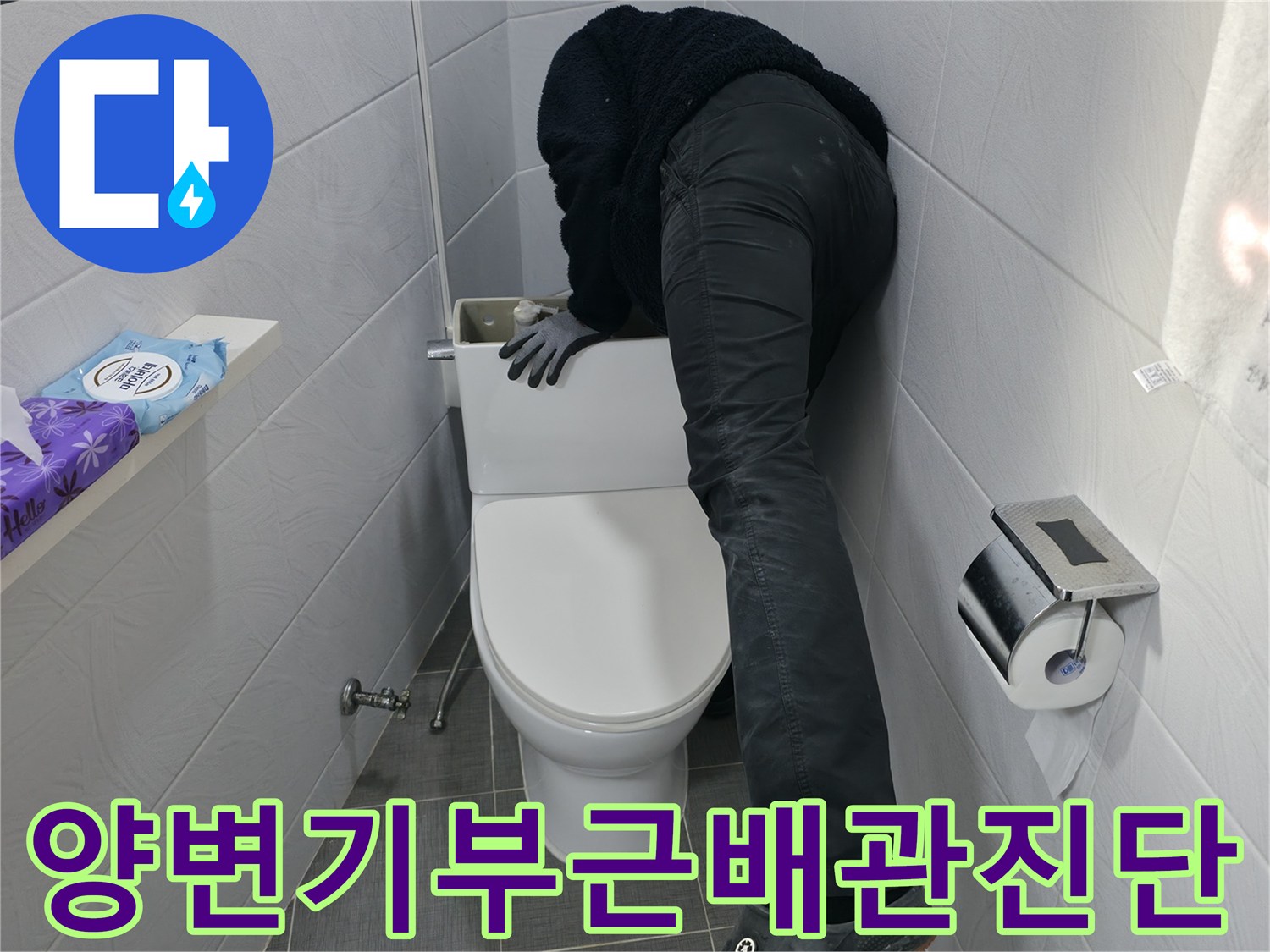 화장실 내 양변기 주변에 위치한 하수 및 오수 배관의 상태를 점검하는 모습