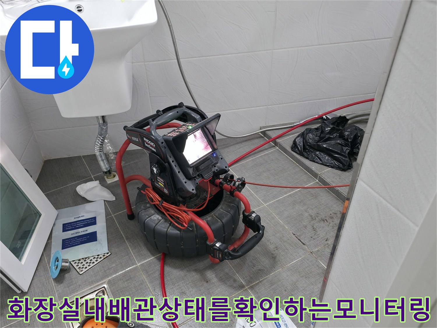 화장실 내부에 배치된 모니터와 탐지 장비를 통해 배관 상태를 실시간으로 확인하는 장면