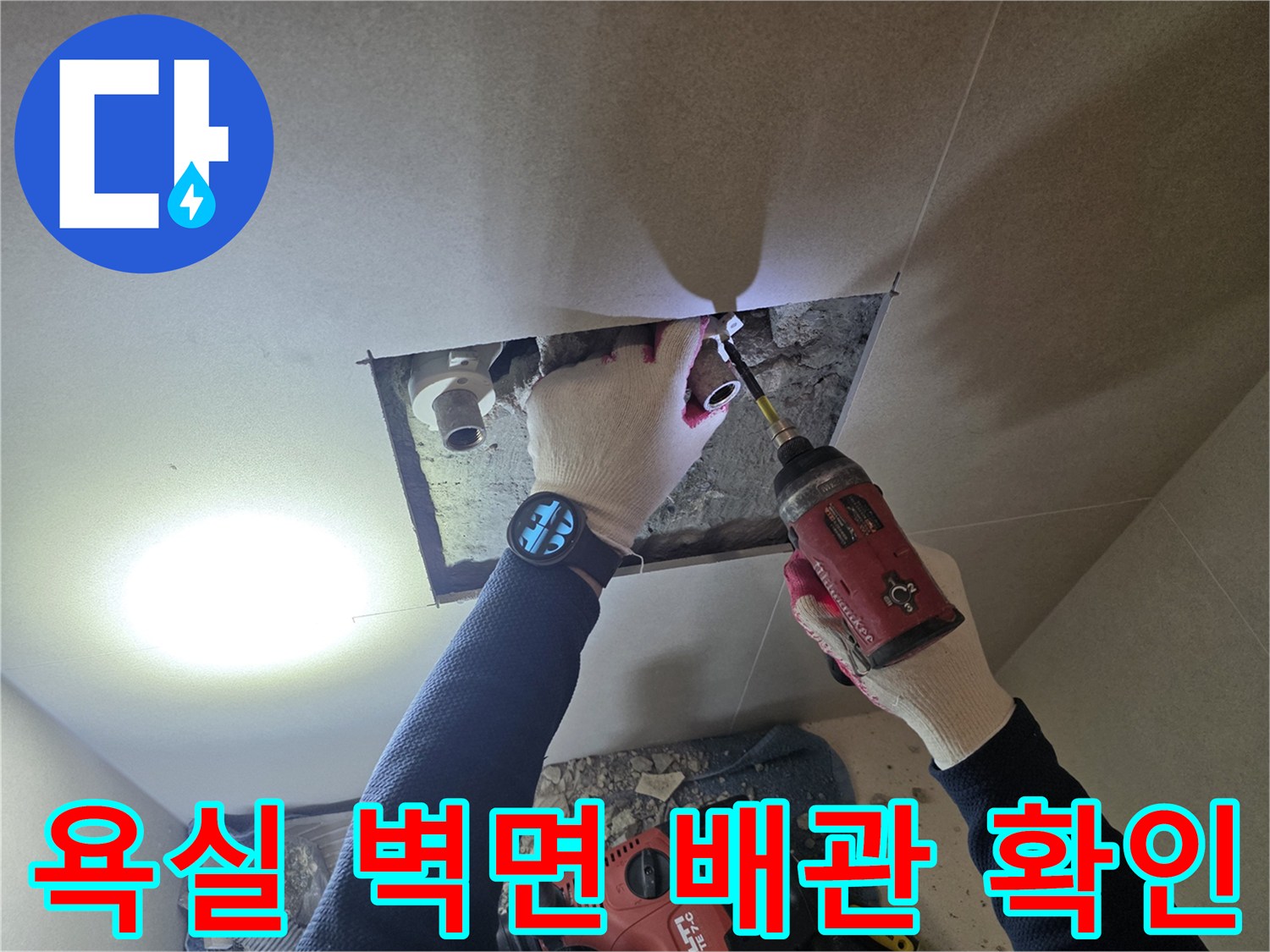 작업자가 흰색 장갑을 끼고 전동 드릴로 배관 부위를 세밀하게 점검합니다.