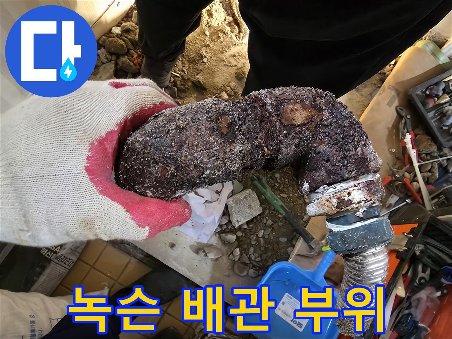 부식이 진행된 금속 엘보 배관과 연결 호스 부분입니다.