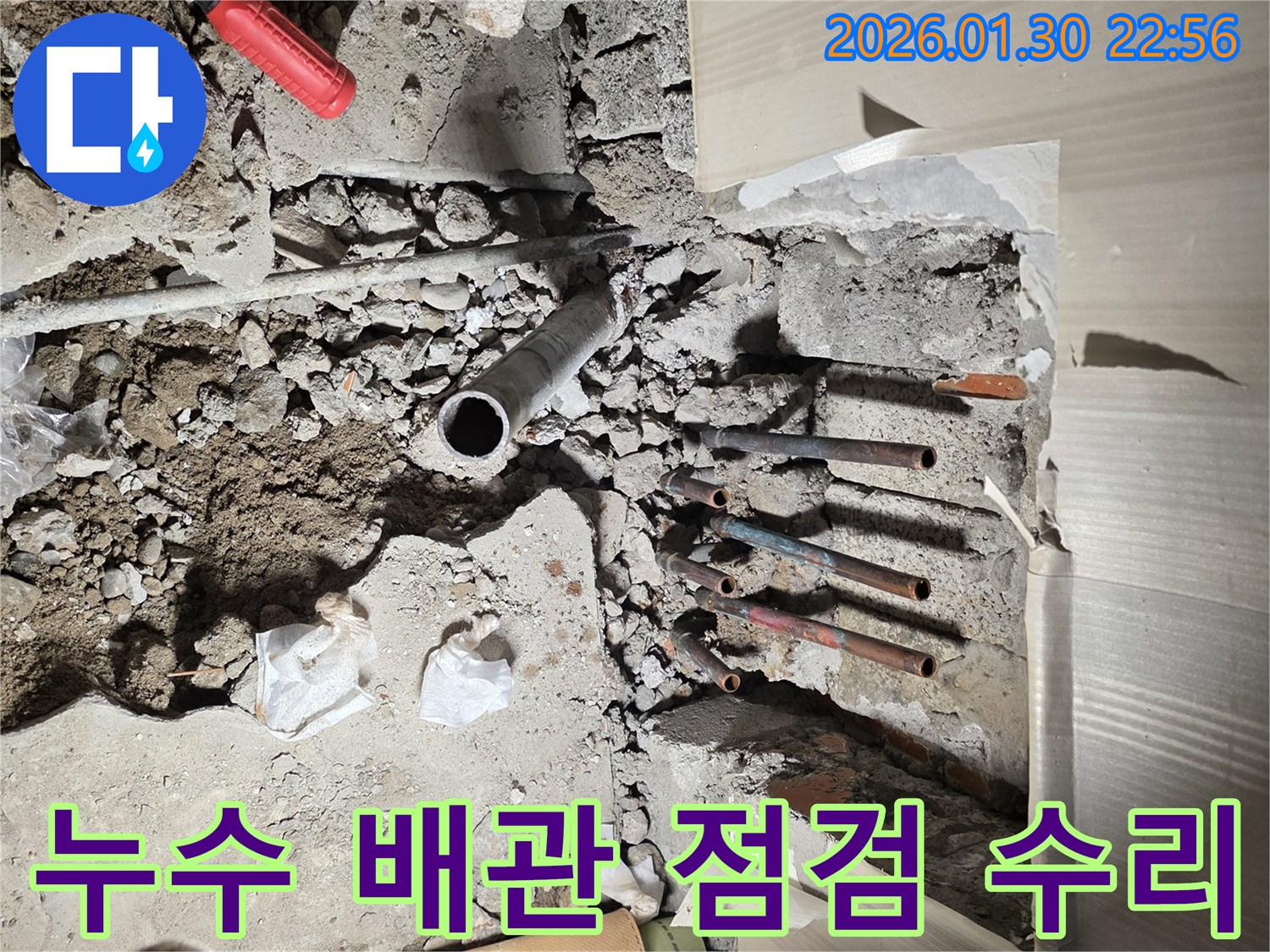 이 사진은-부천 역곡동의-누수 현장에서-바닥을 파쇄한 후-노출된 배관들을-점검하고 수리하기 전-모습을 보여줍니다