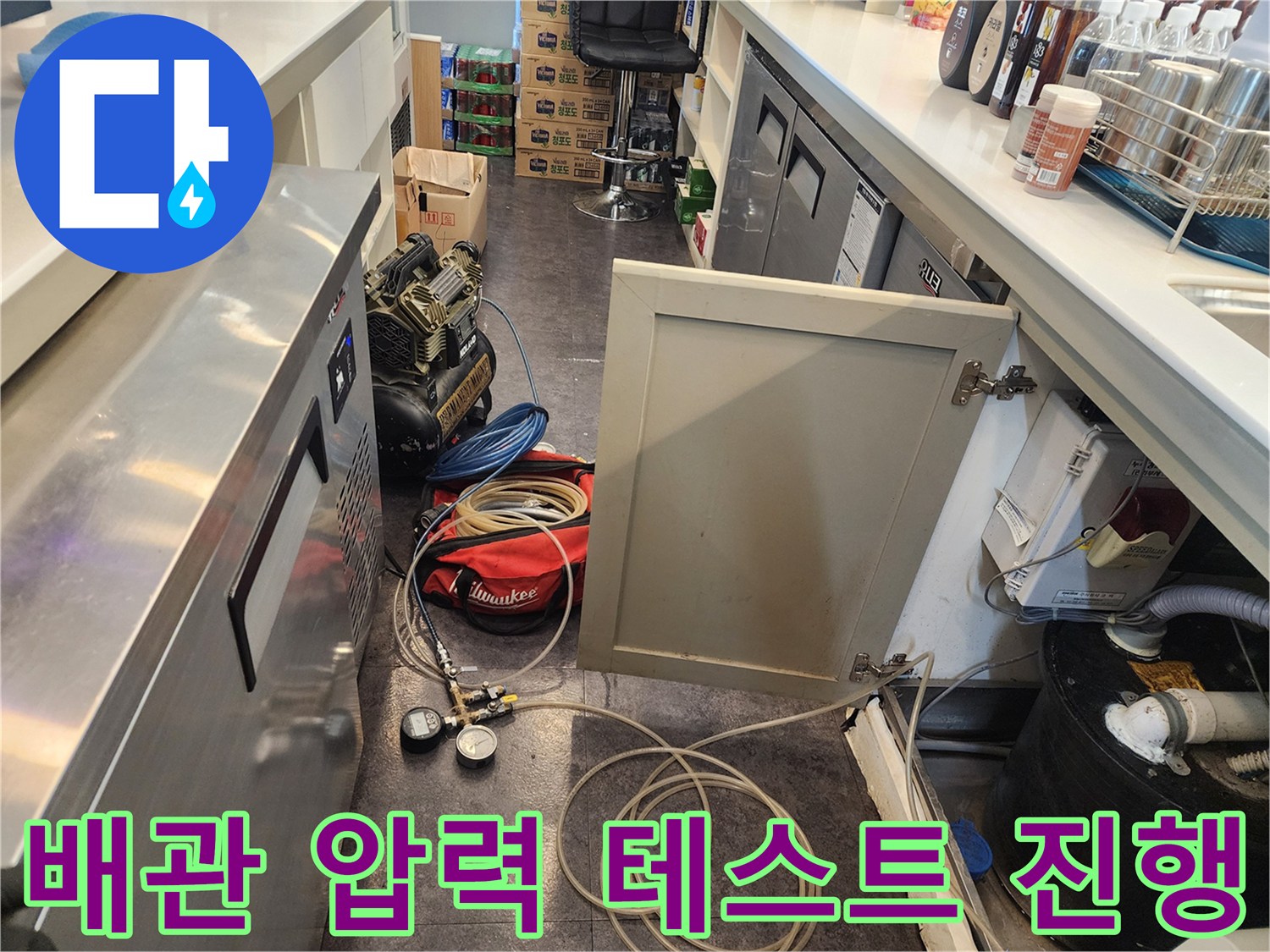 주방 설비 하단 배관에 연결된 누수 탐지용 압력계와 호스 상태