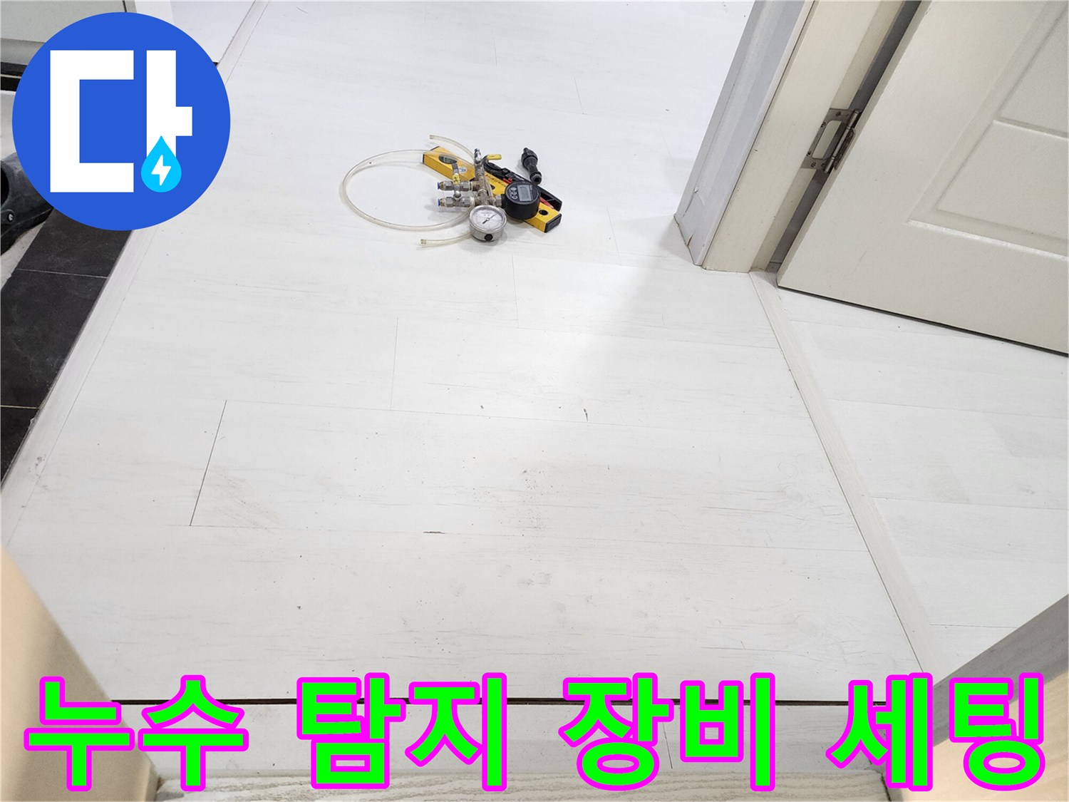 하얀 타일 바닥에 배치된 압력계와 연결 호스 뭉치