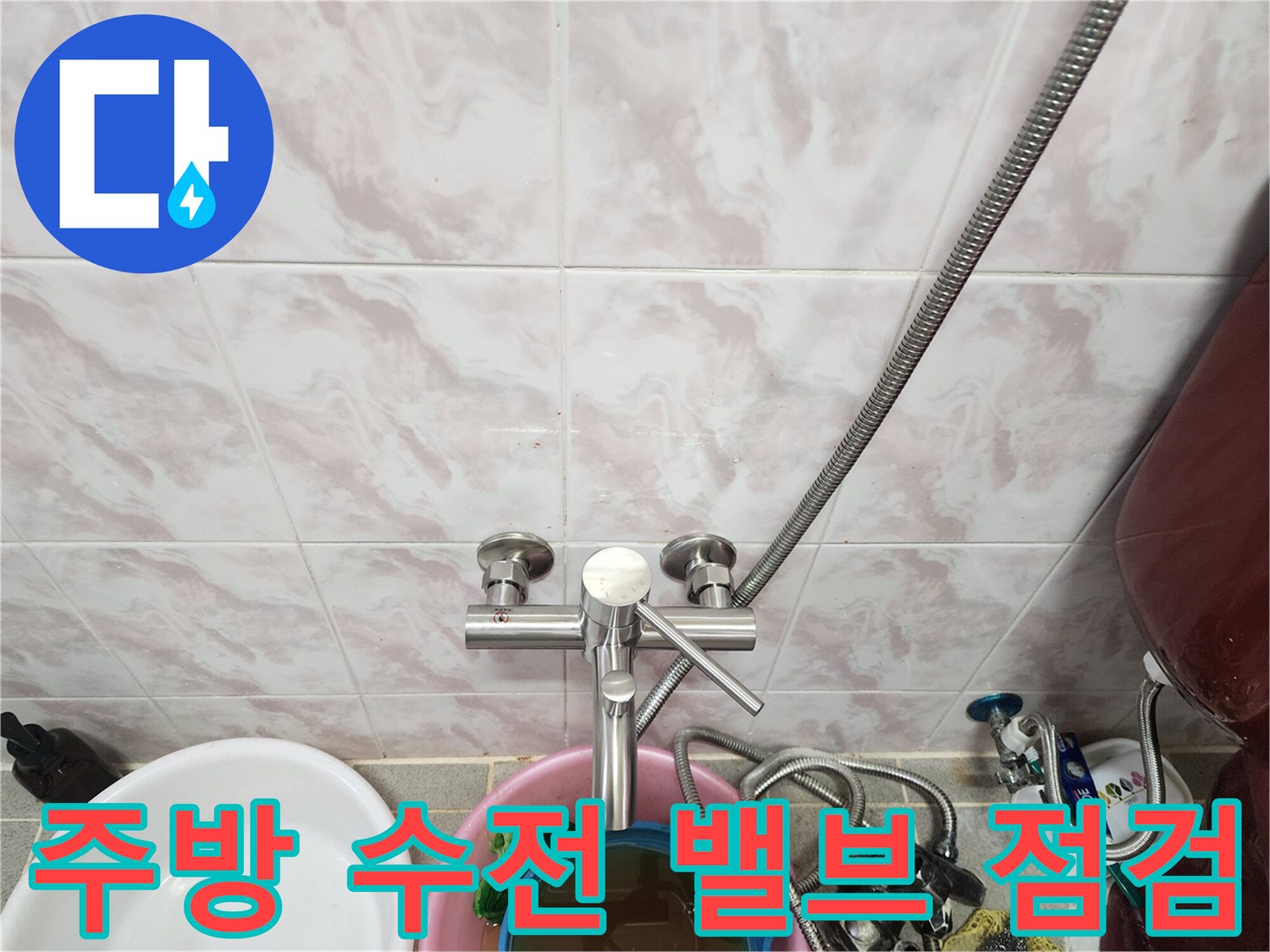 벽면에 설치된 수도 밸브와 연결 호스의 근접 촬영 이미지입니다.