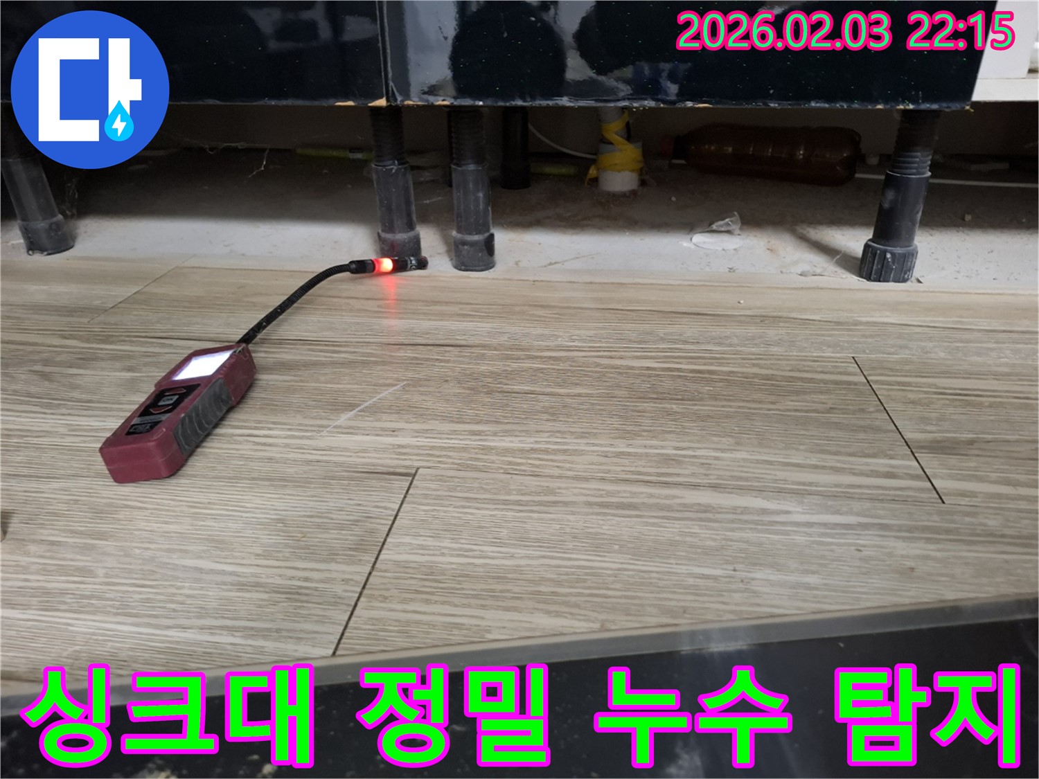 싱크대 하부에서 누수 탐지 장비로 누수를 탐지하는 모습 - 작은 물방울도 놓치지 않습니다.