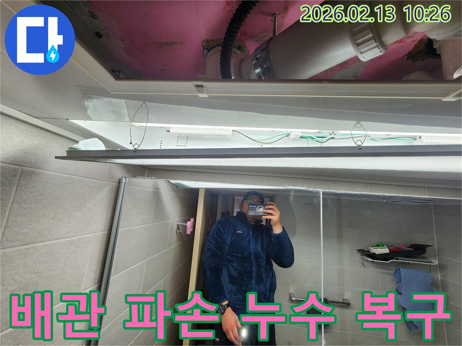 누수 엔지니어가 화장실 천장 점검구를 열고-파손된 배관으로 인한 누수 상황을 확인하고 있습니다.