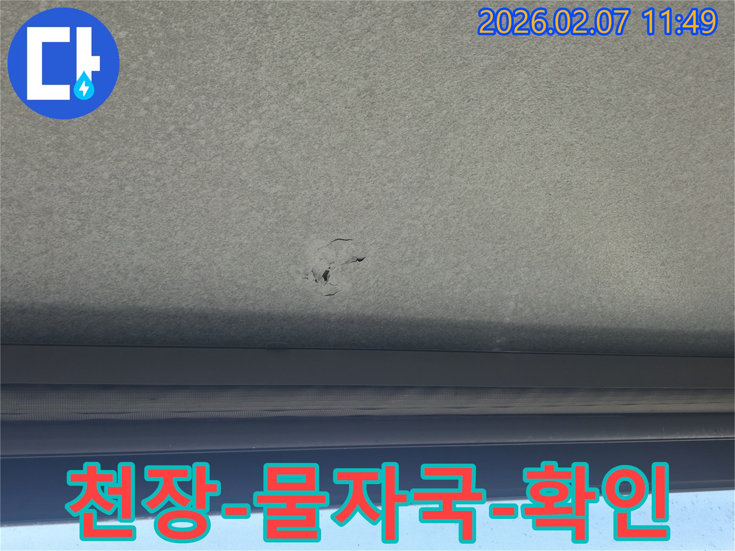 천장에-생긴-누수-구멍과-주변의-물자국을-자세히-보여주는-사진입니다.