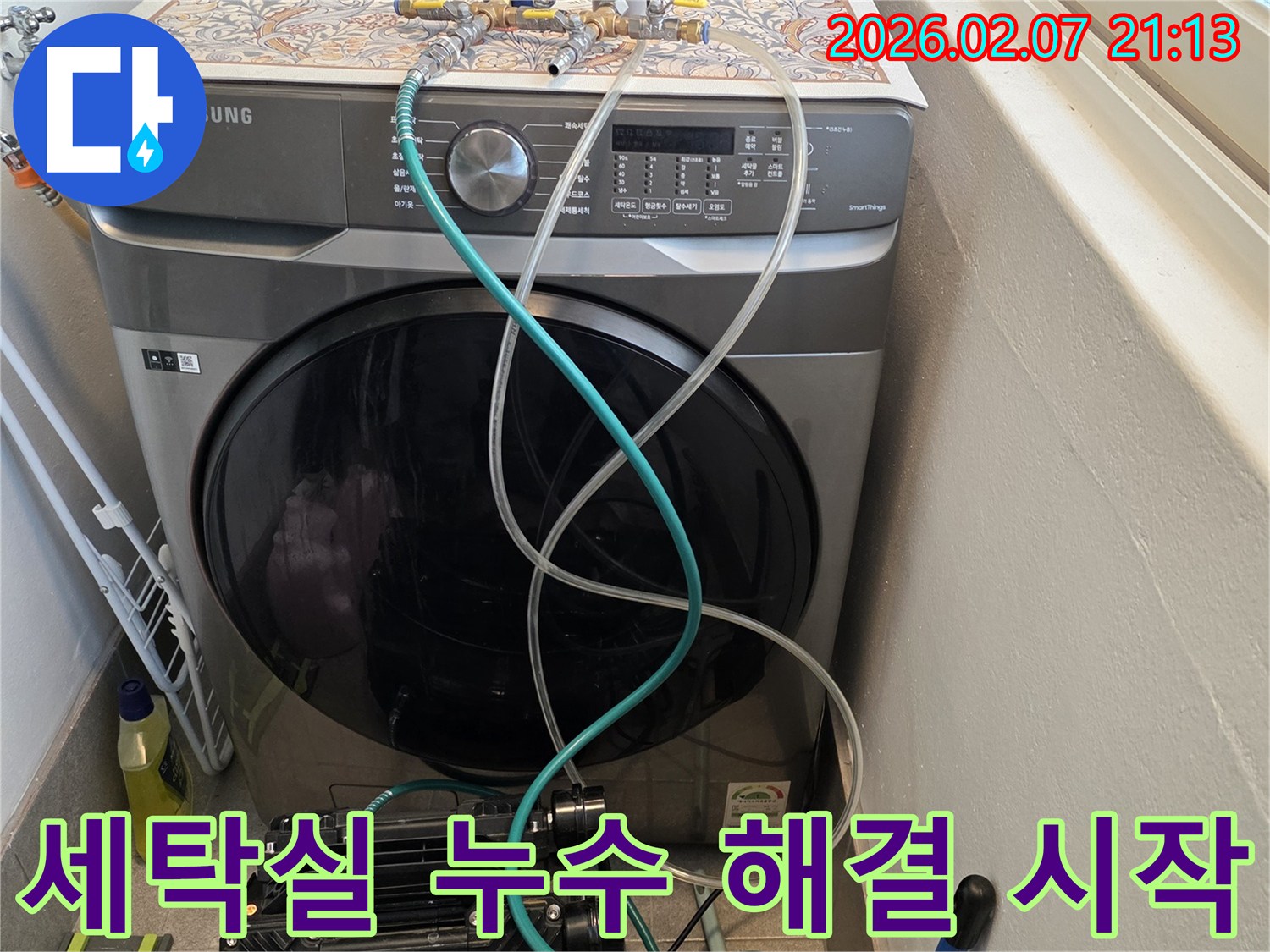 세탁기-옆-배관에-연결된-장비로-세탁실-누수-문제-해결을-시작하는-모습입니다