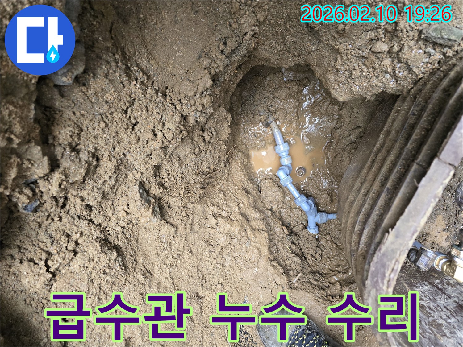 땅속에 매설된 급수관의 연결 부위에서-물이 새어나와 주변 흙이 젖고-물이 고여있는 누수 현장입니다