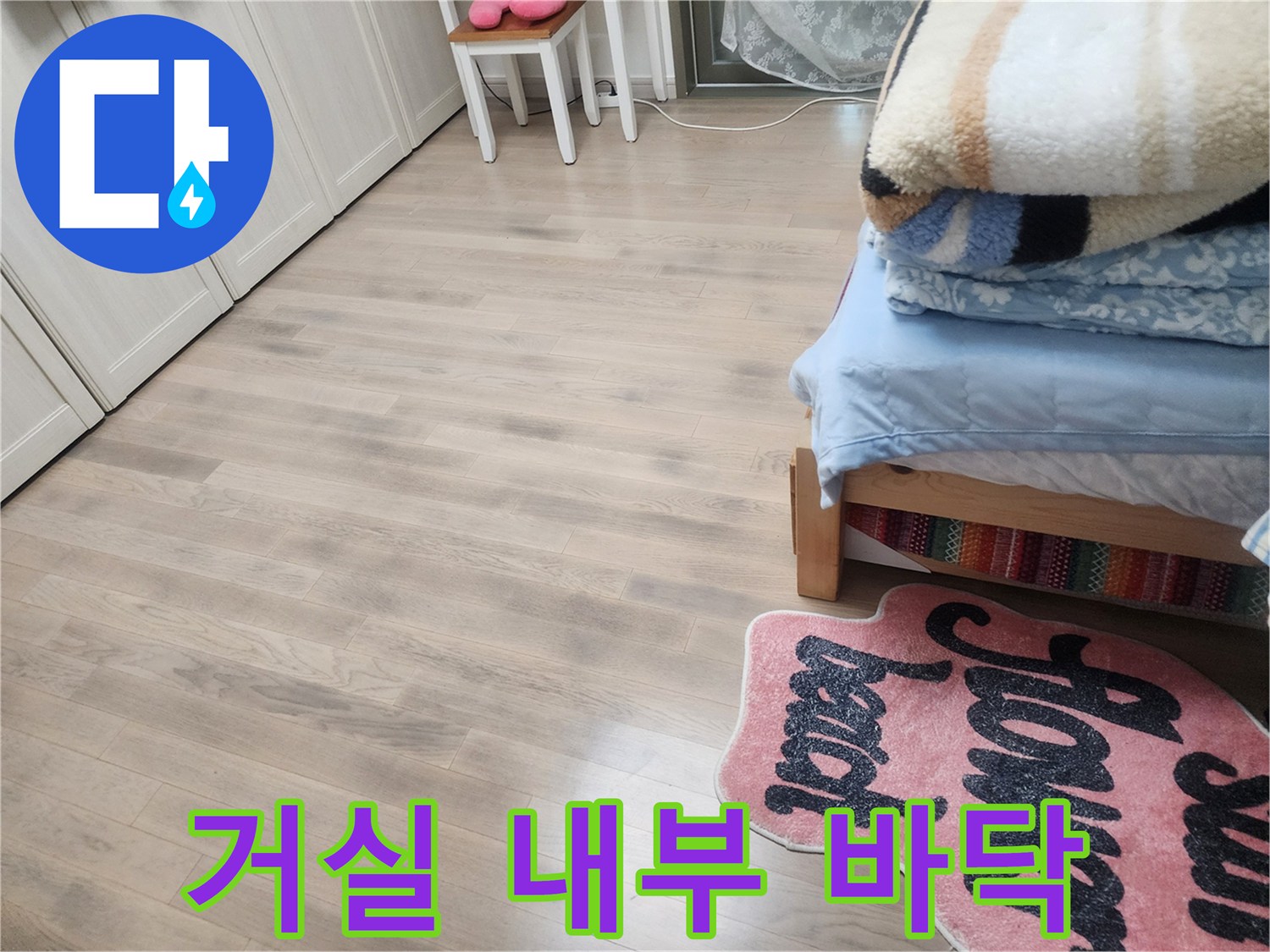 밝은 색상의 아파트 거실 마루와 가구 배치 모습