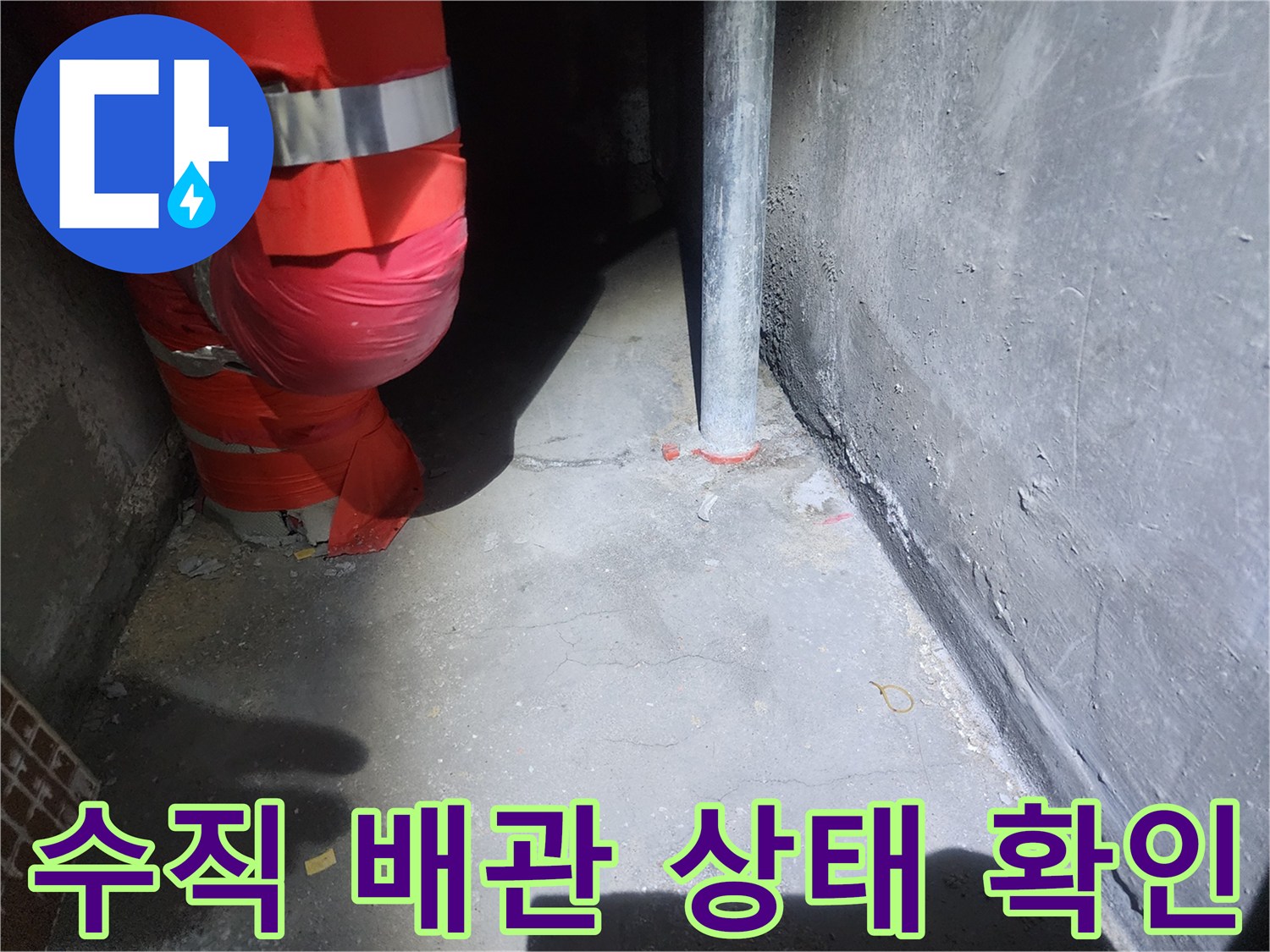 천장 내부의 붉은색 보온재 배관과 회색 수직 파이프 사진입니다.