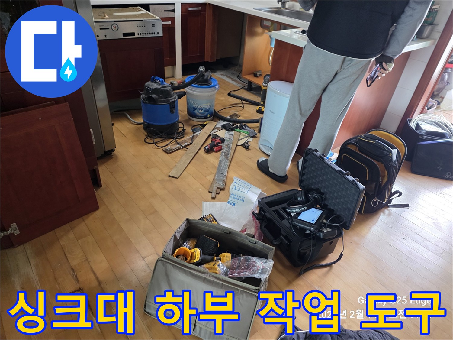 탈거된 싱크대 밑 공간에 배치된 누수 탐지 및 청소용 전문 기기들