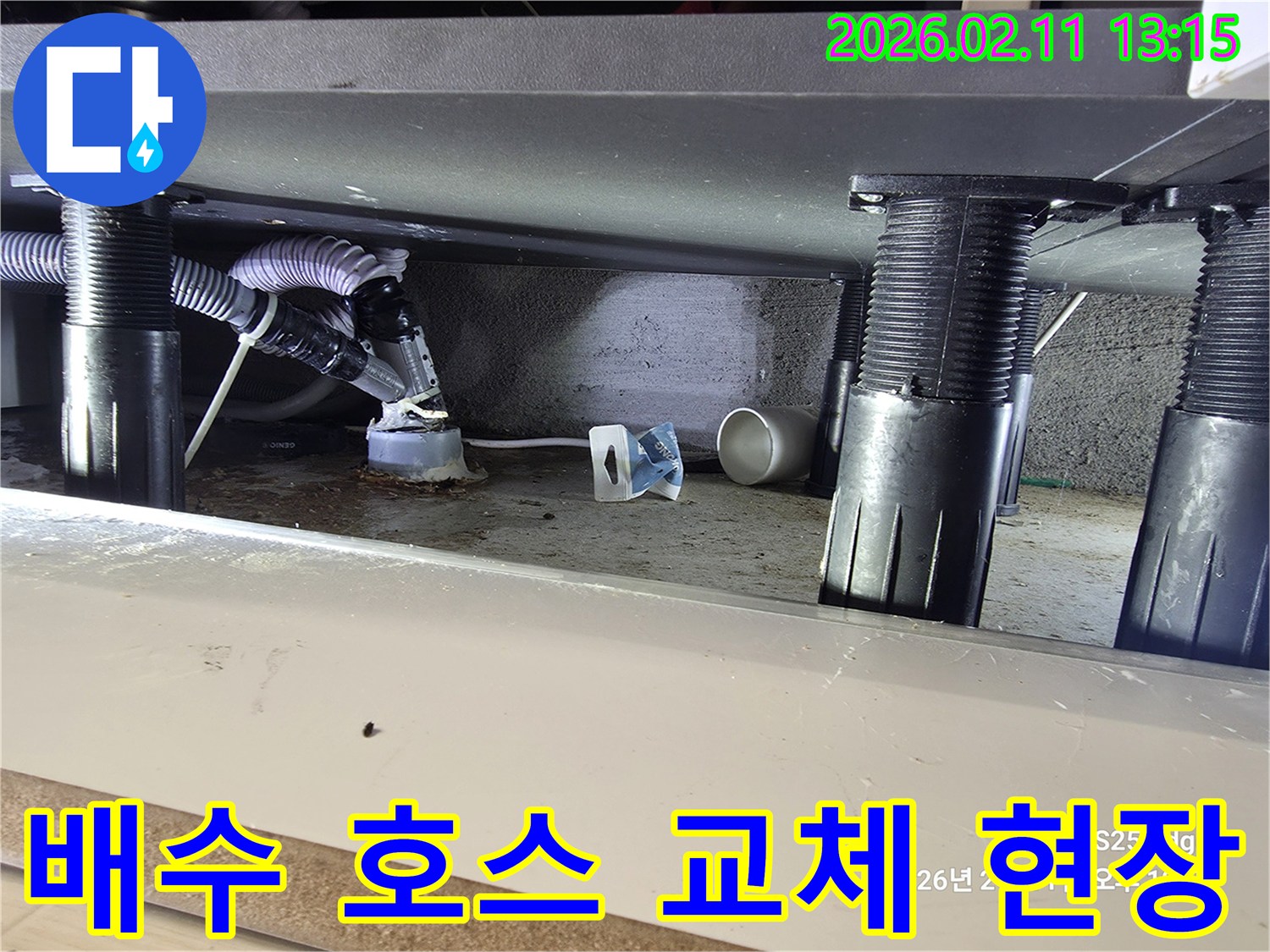 싱크대 하부의 노후된 배수 호스에서 발생한 누수를-해결하기 위해 교체 작업이 진행되고 있는 현장 모습