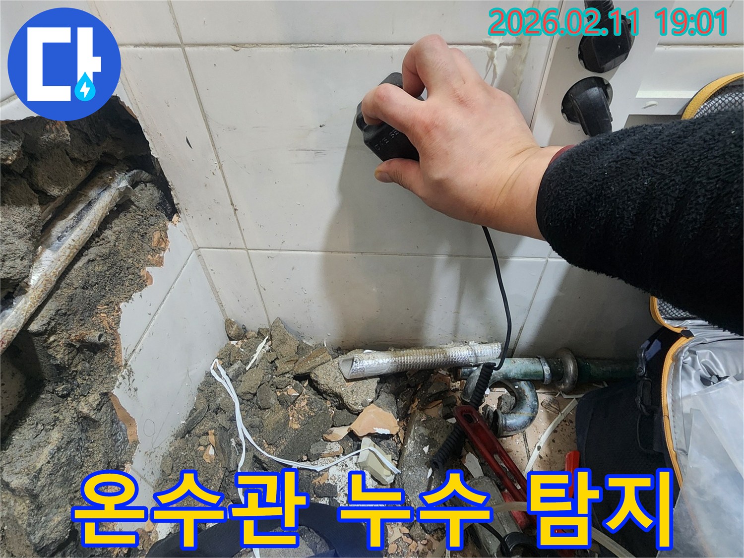 누수 전문가가-온수관 누수 지점을-찾기 위해-탐지 장비를 활용하여-작업하는 현장입니다
