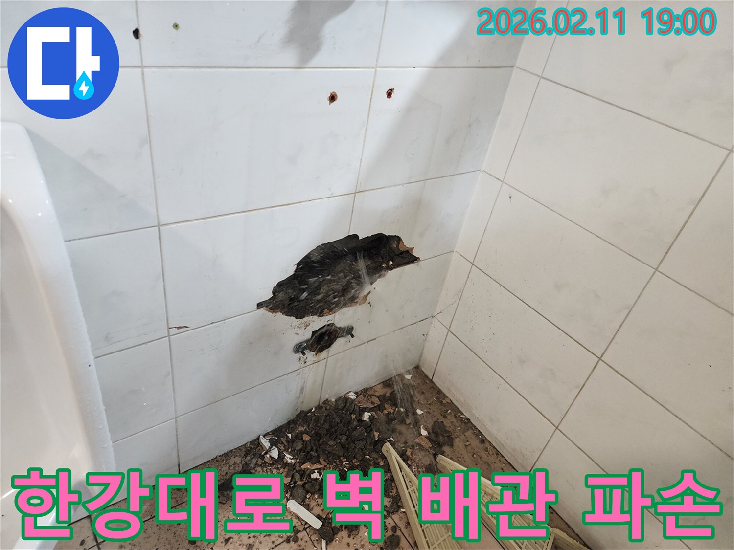 서울 용산구 한강대로 인근-건물 벽에서-타일 손상과 함께-물이 새는 배관 파손 현장을-전문가가 점검하는 모습