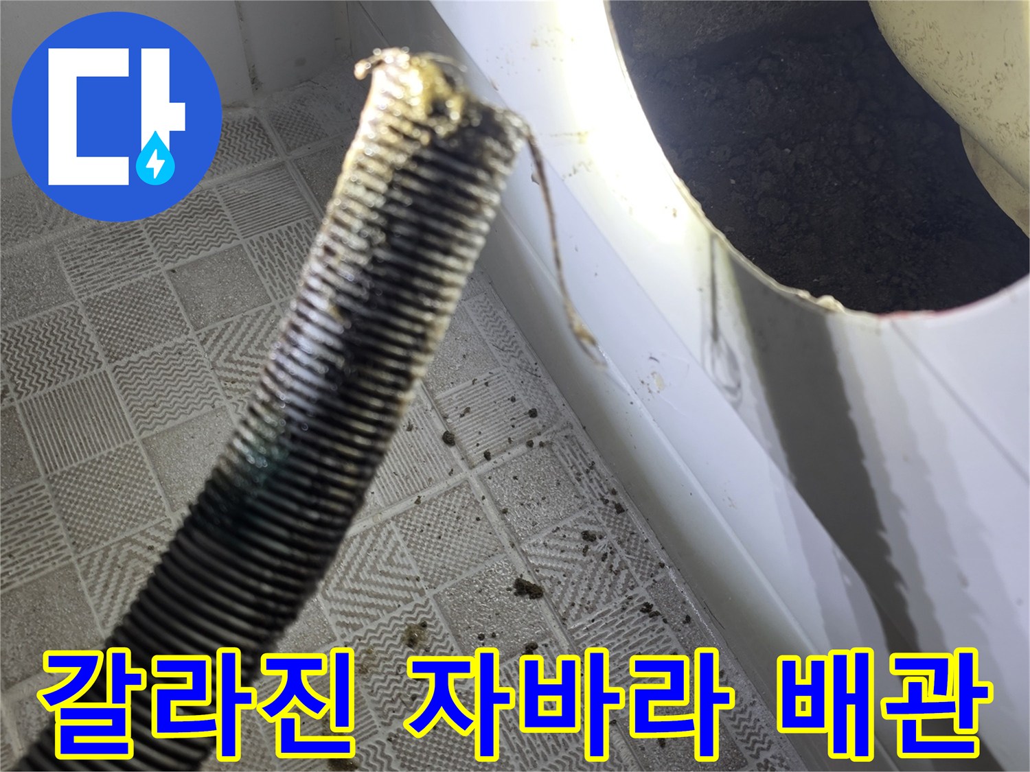 찢어진 틈 사이로 물이 새어 나오는 배수관 모습