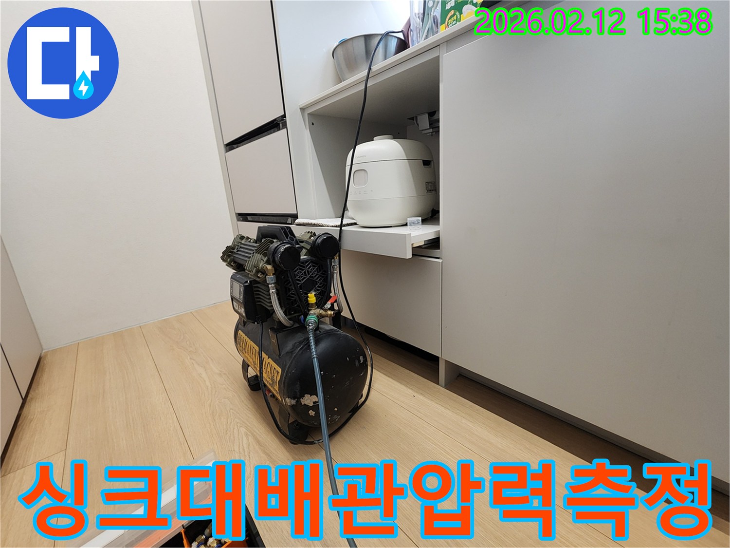 싱크대 아래 배관에서 발생한-미세 누수를 찾기 위해-압력 테스트 장비를 연결했습니다