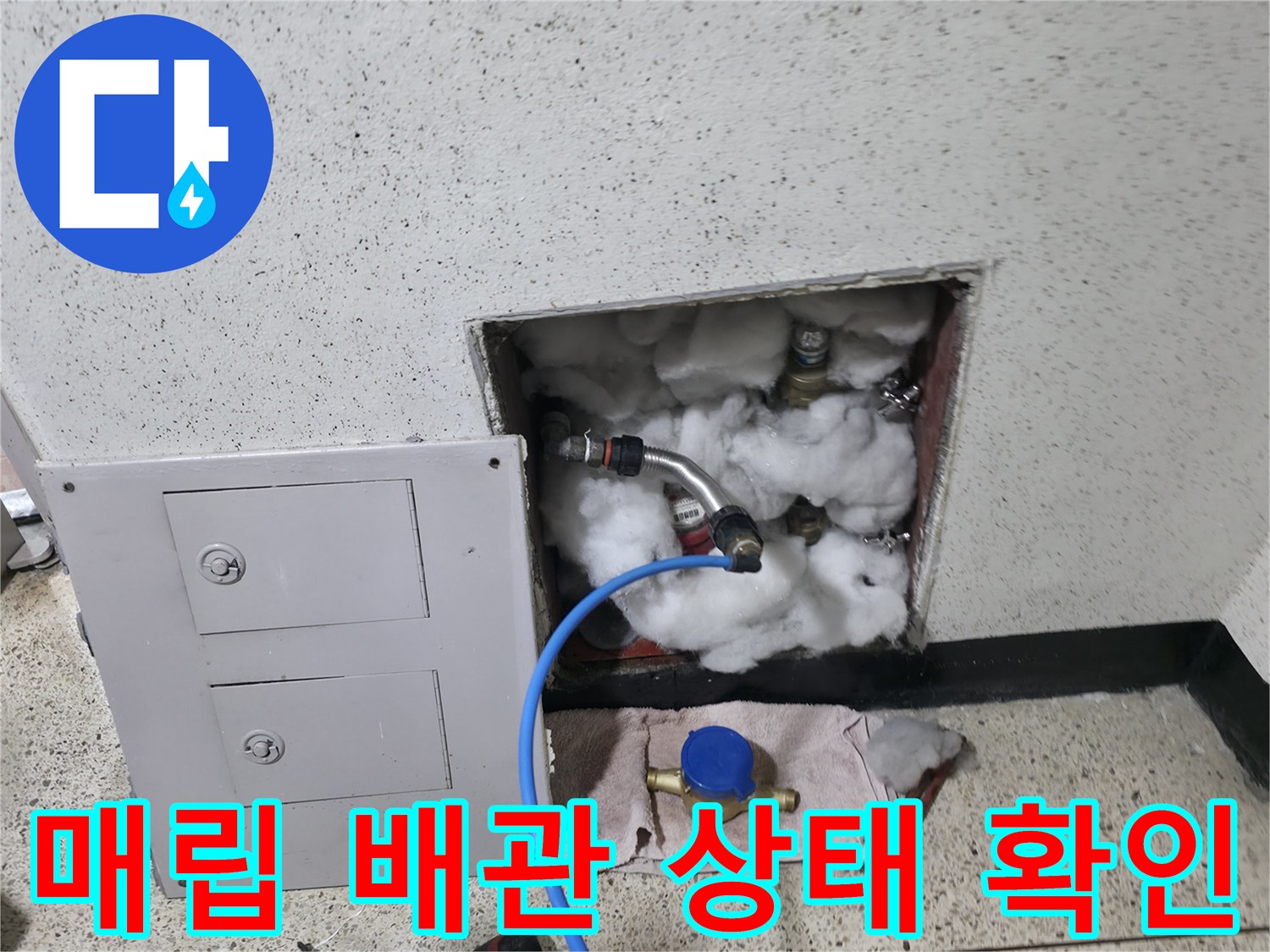 벽면 점검구를 통해 드러난 수도 배관과 압력 측정 장치