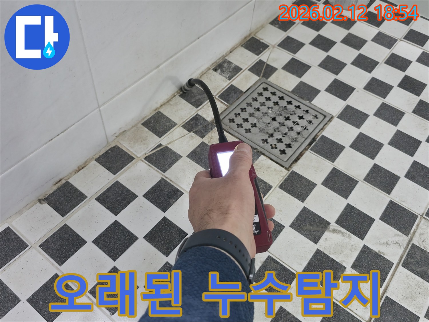 전문 엔지니어가-고객님의 오래된 욕실에서-누수 탐지 장비로-누수 지점을-꼼꼼히 확인하고 있습니다.