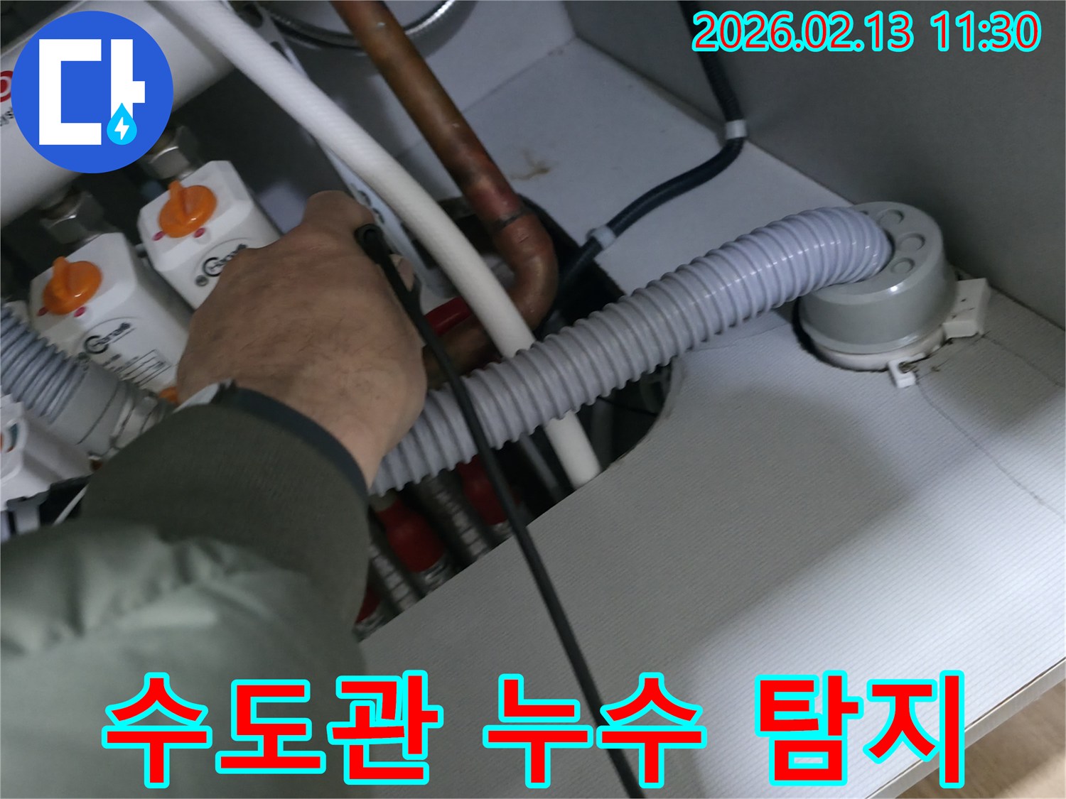 누수 전문가가-정밀 청음식 탐지기로-수도관의 미세한-누수음을 감지하고 있습니다.