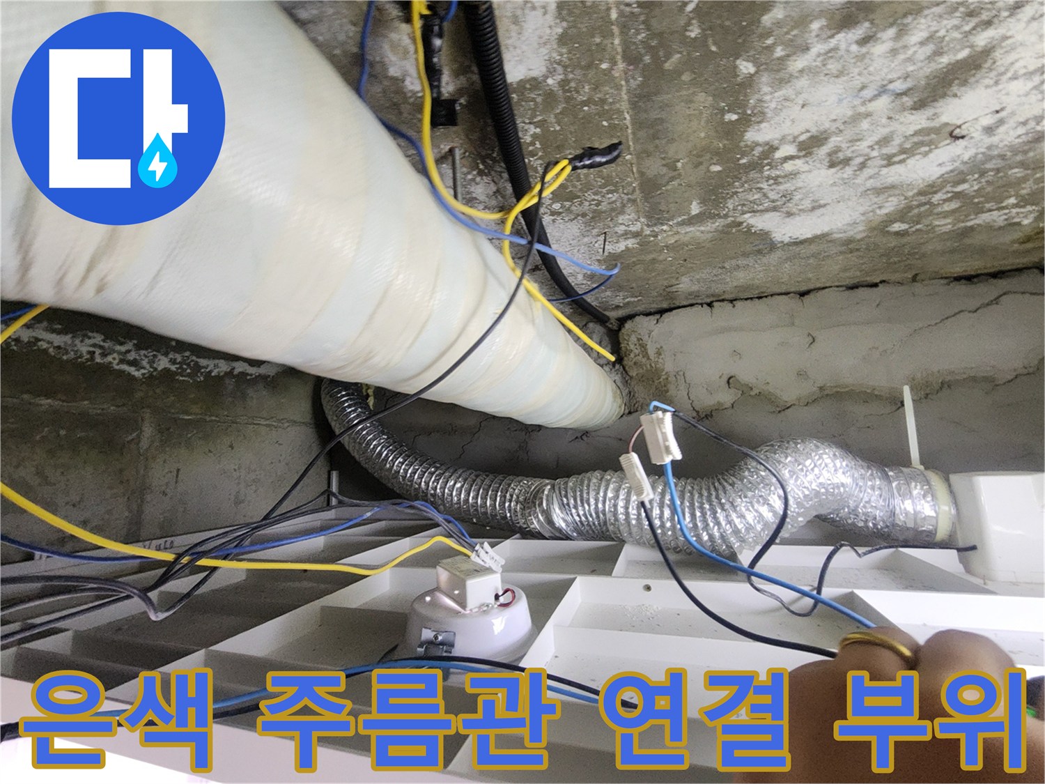 천장 내부의 흰색 굵은 관과 은색 배수 호스 근접 촬영