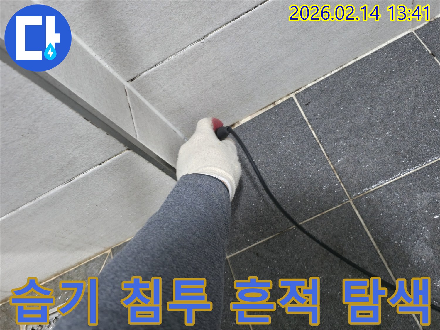 누수 엔지니어가-장갑을 끼고-누수 탐지 장비를 활용하여-타일 하부에 숨겨진-습기 침투 흔적을 찾아내는 모습입니다.