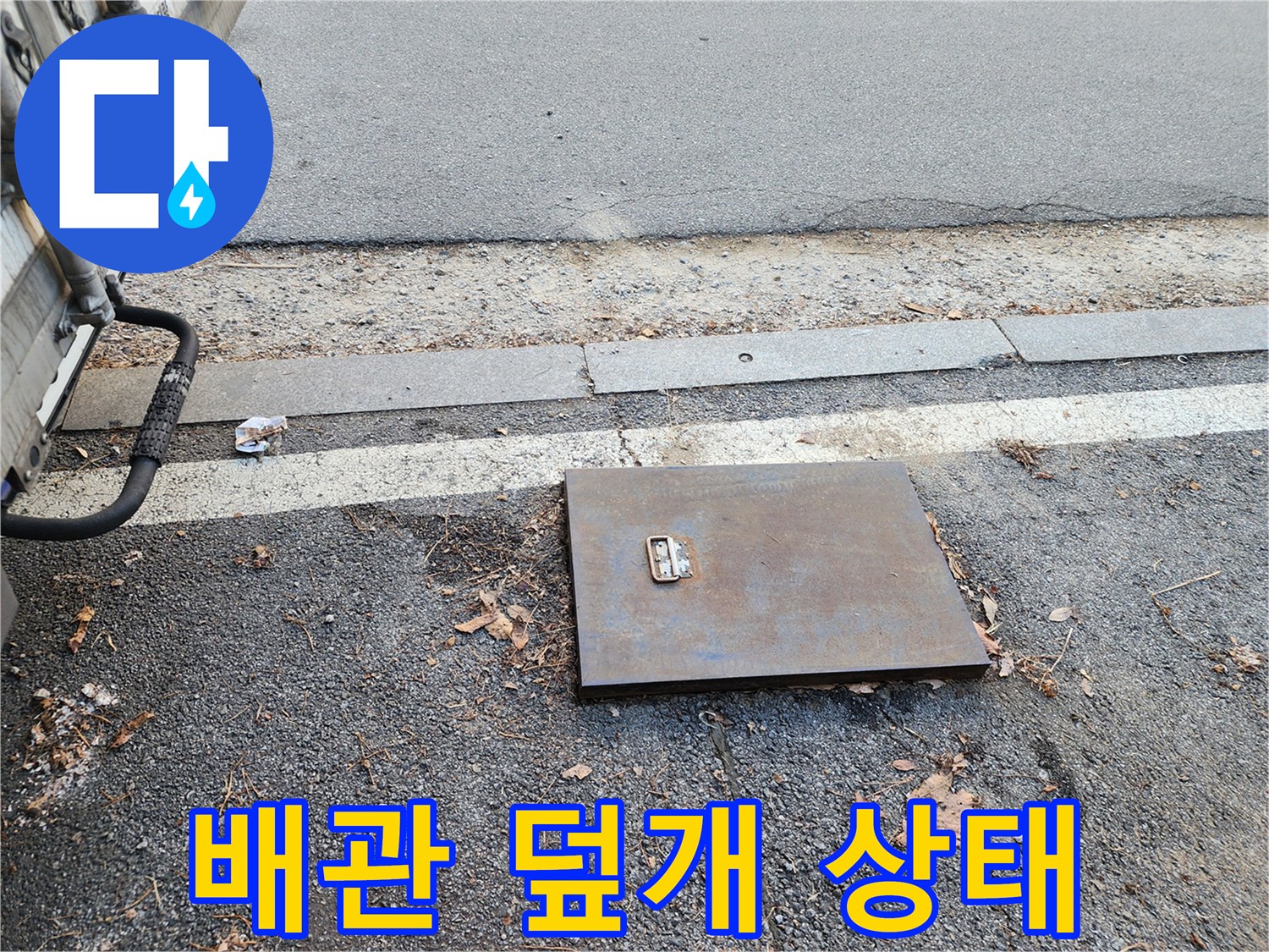 아스팔트 도로변-금속 재질의 계량기 함 덮개 사진