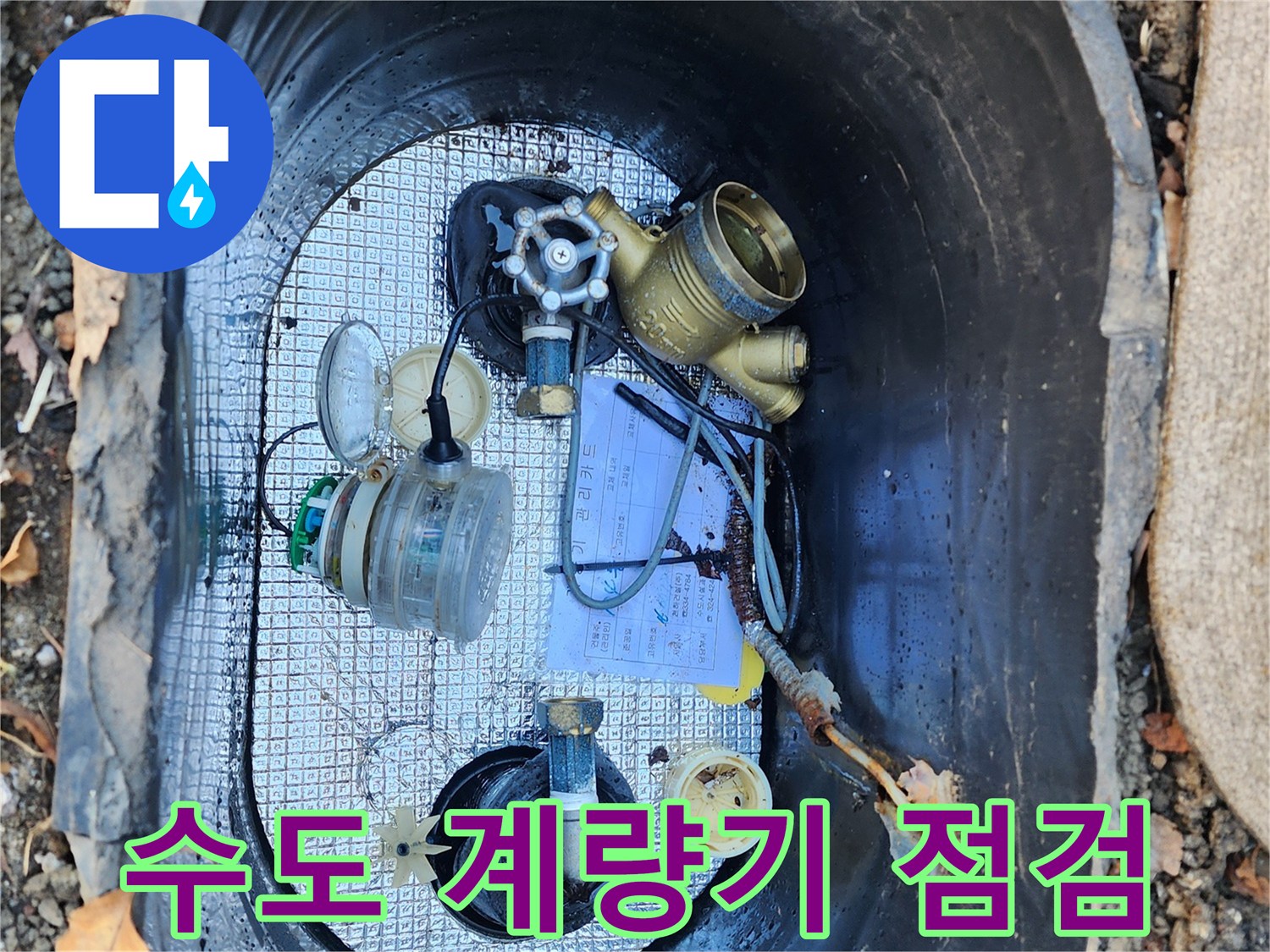 좁은 계량기 함 내부에 복잡하게 연결된 수도 배관과 장비들