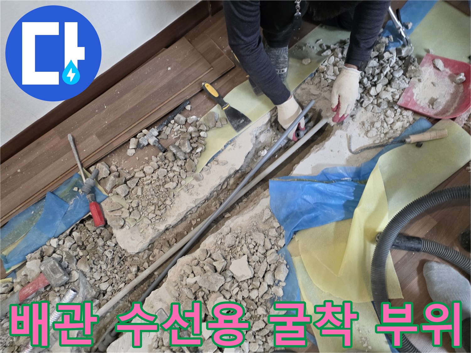 콘크리트 파편과 함께 드러난 배관 수선을 위한 작업 현장 사진