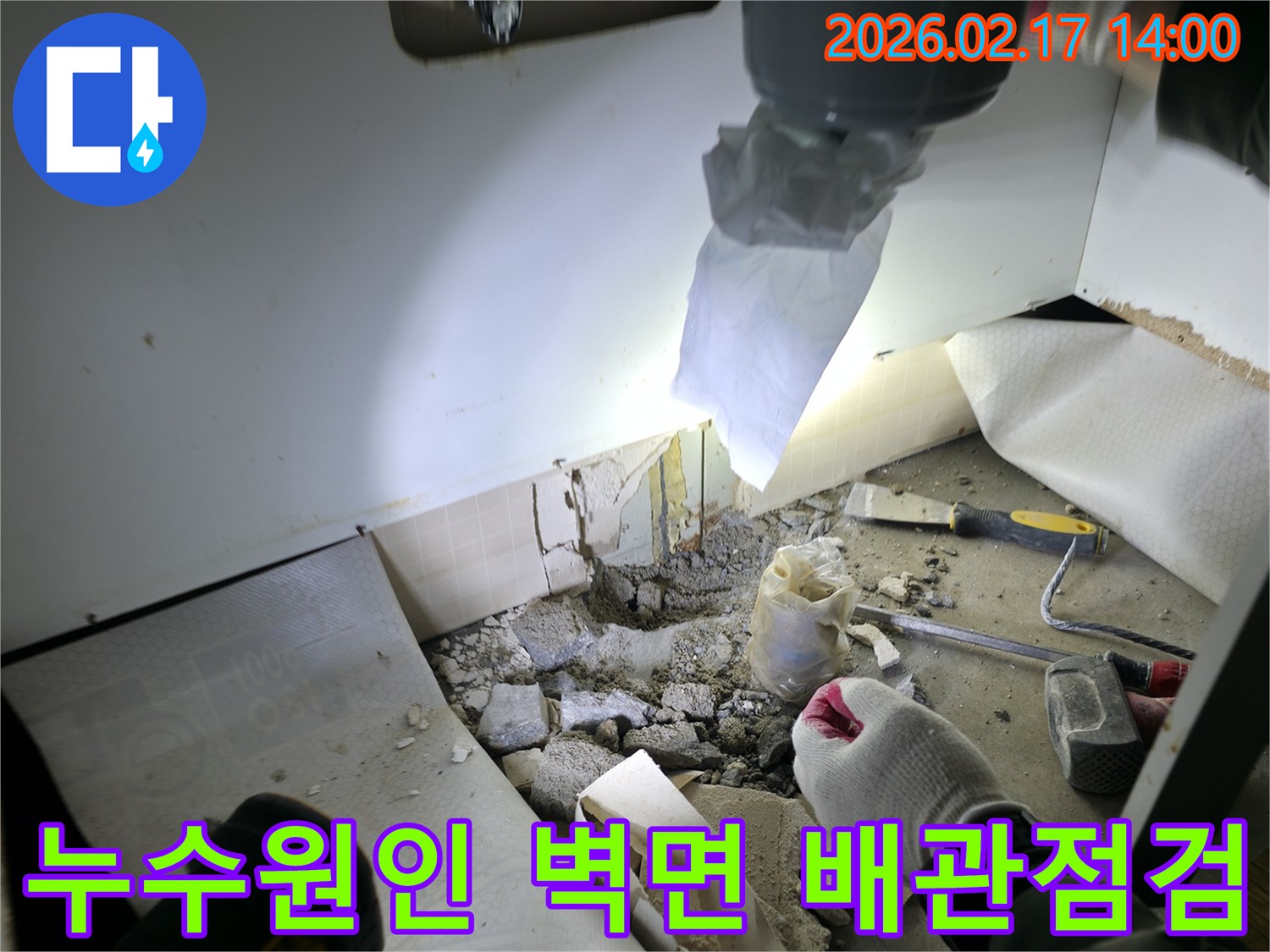 누수 원인 분석 현장에서-벽면을 파쇄하여-손상된 배관을 점검하는 모습