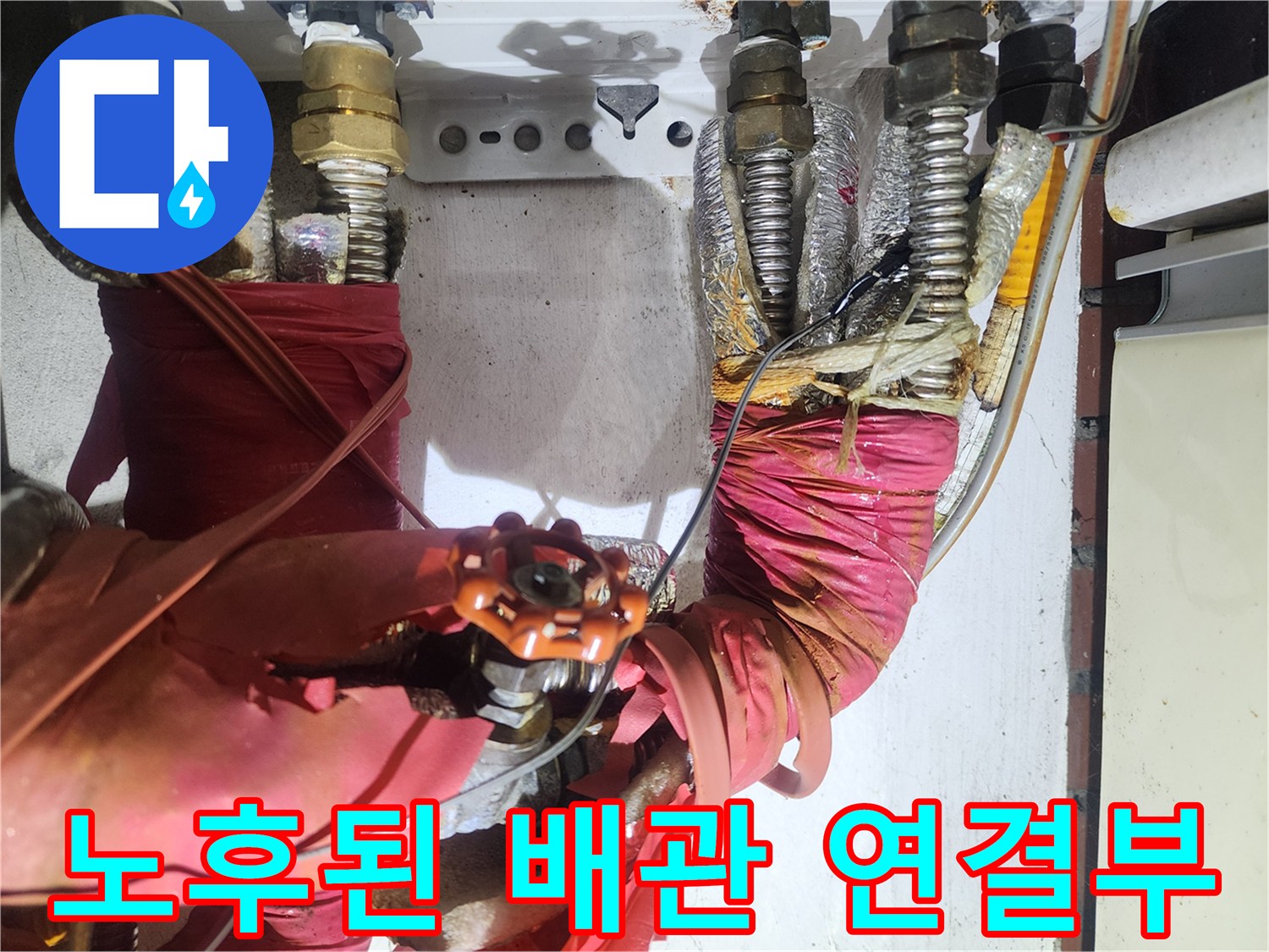 붉은색 보온재와-금속 밸브가 있는 배관 구조