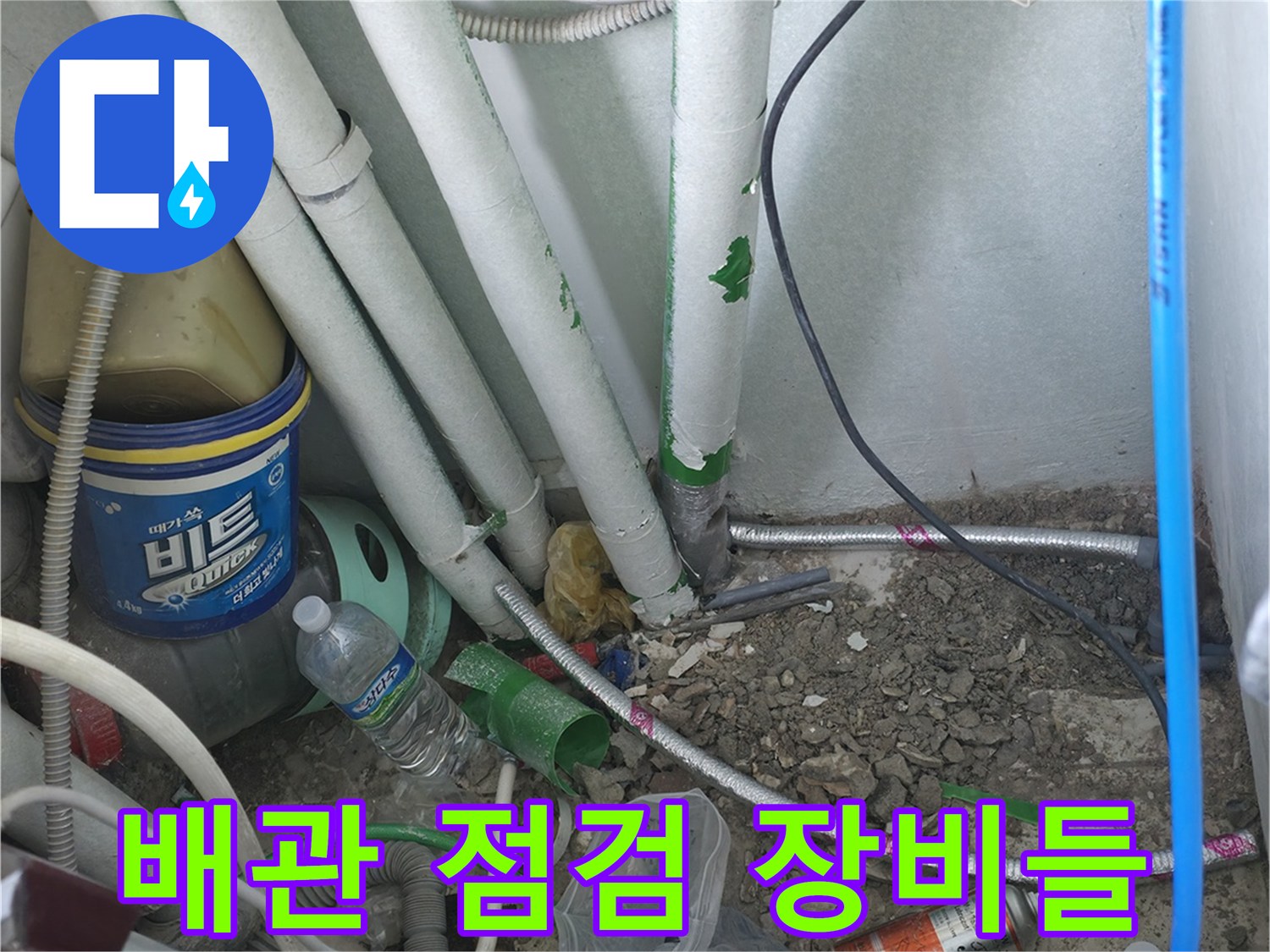바닥 배관 근처에 배치된 테스트용 호스와 자재들