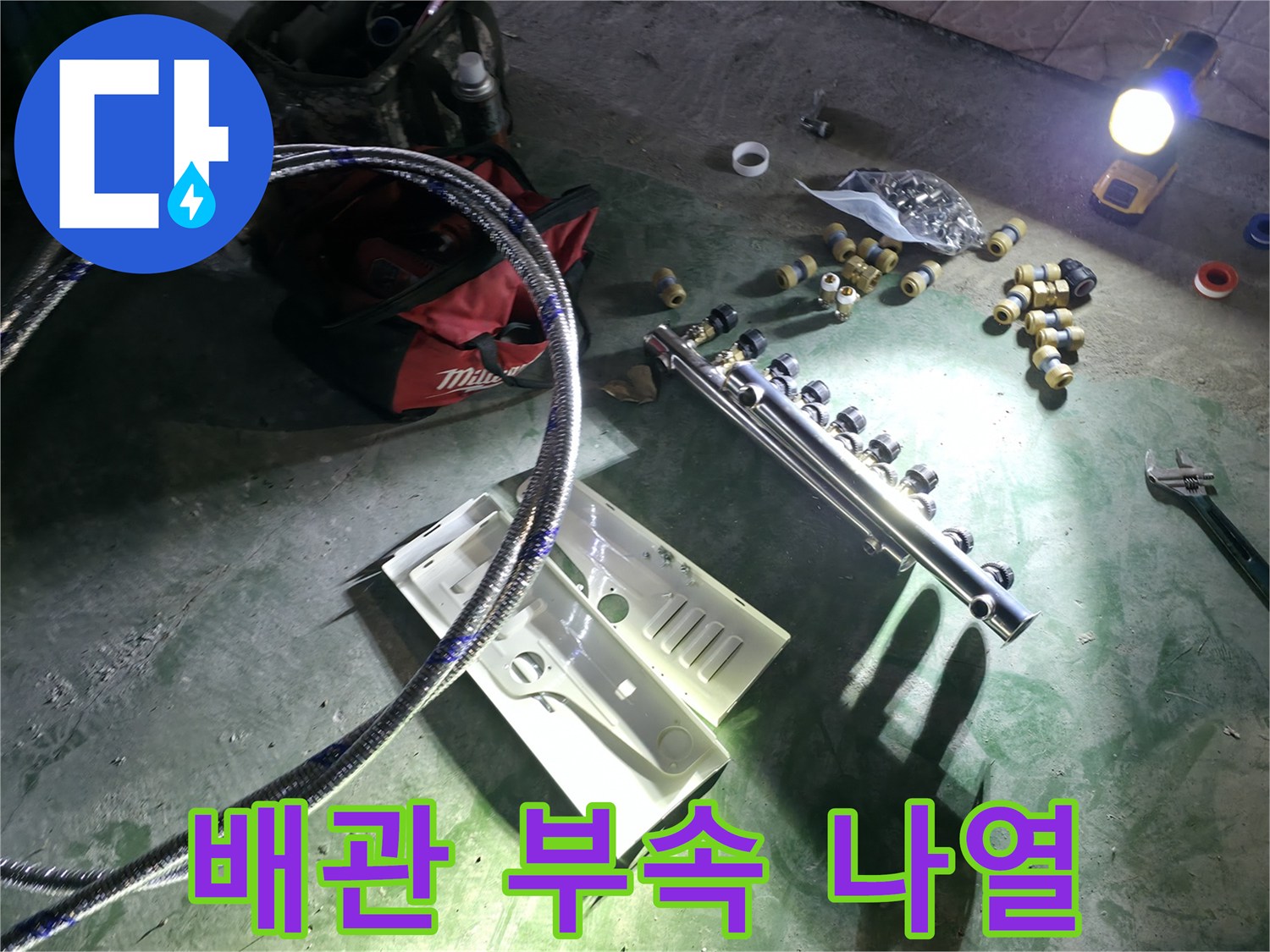 누수 공사를 위해 바닥에 배치된 매니폴드와 배관 연결 소품들