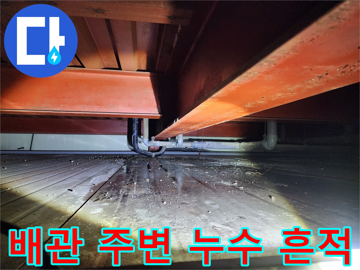 배관과 구조물 사이 바닥에 고여 있는 물기를 촬영한 사진입니다.