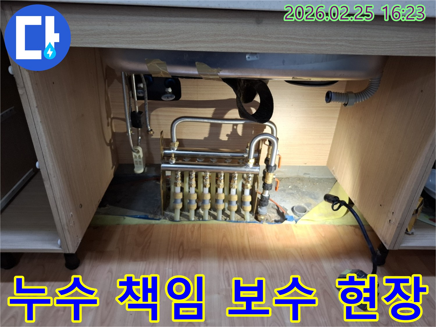 싱크대 하부의 배관 분배기에서 발생한 누수를 책임지고 보수하기 위해 점검하는 모습입니다.