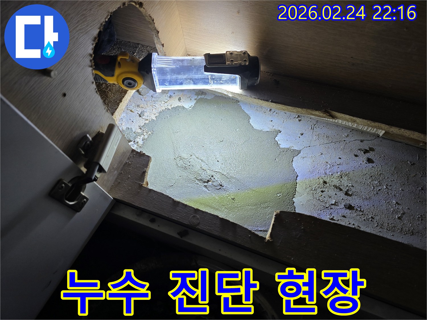 누수-엔지니어가-좁고-어두운-공간에서-누수-진단을-위해-조명-장비를-사용하여-정밀하게-살펴보는-모습