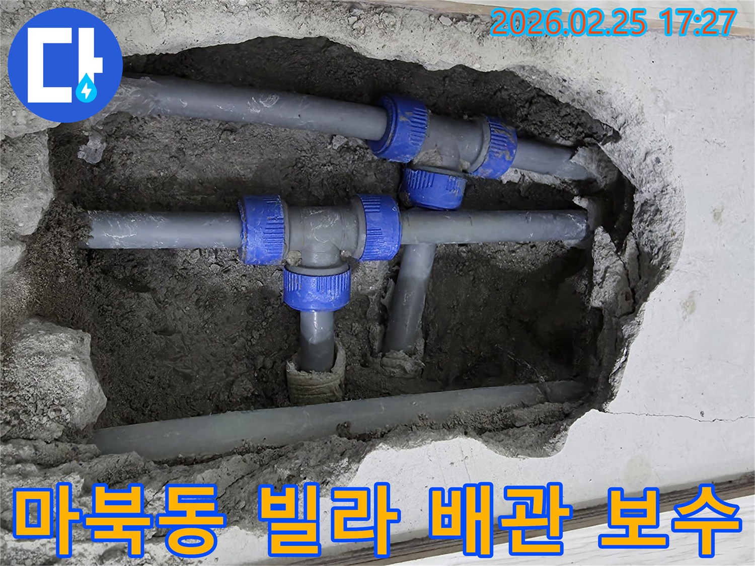 콘크리트 바닥을 깨고 드러난-파란색 연결 부속이 있는 회색 배관들-누수 지점을 보수하기 위한 작업 현장