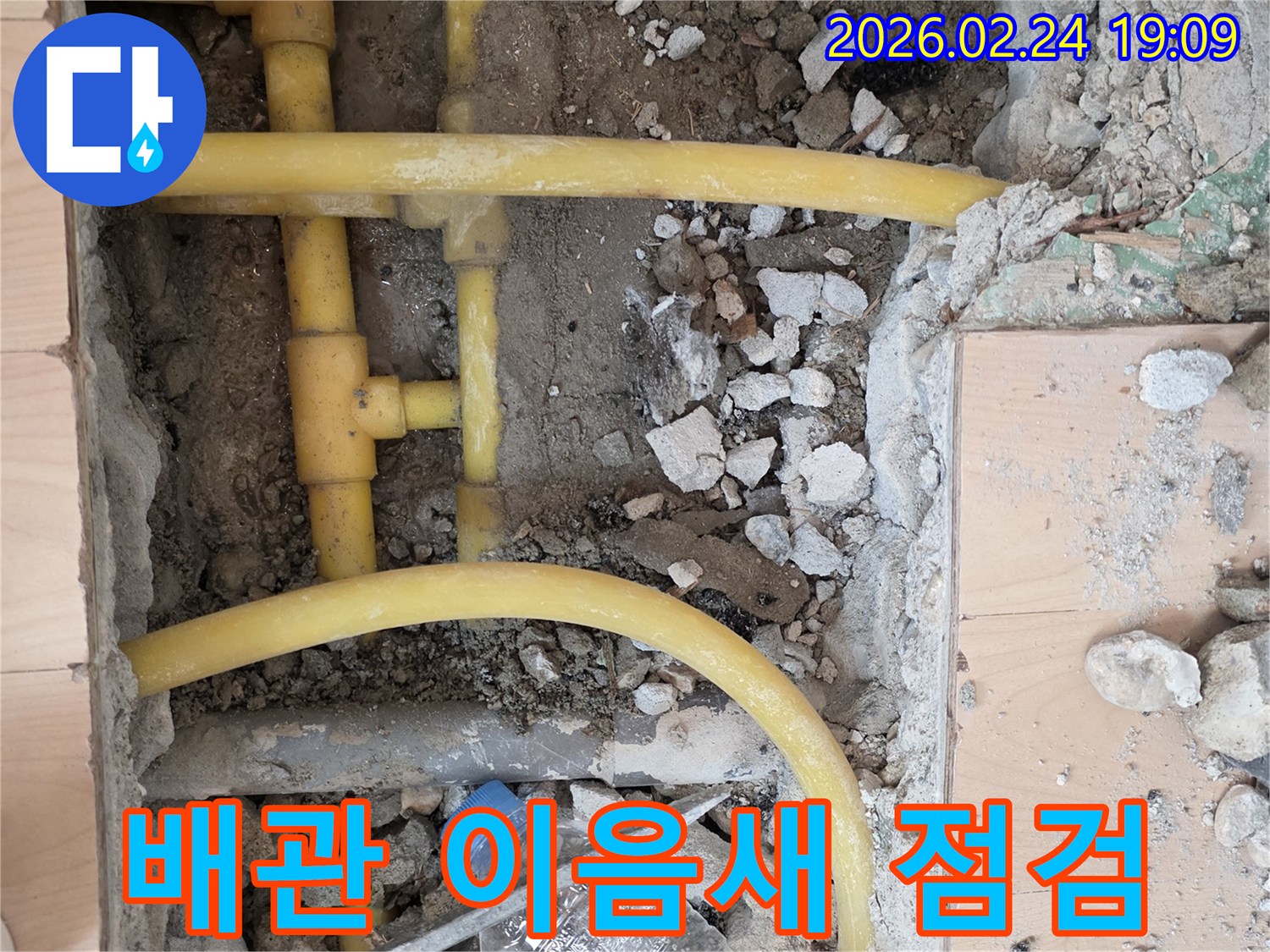 누수 점검을 위해 바닥을 파쇄하고-노출된 배관의 이음새와 연결부를-꼼꼼하게 확인하는 작업 현장입니다.