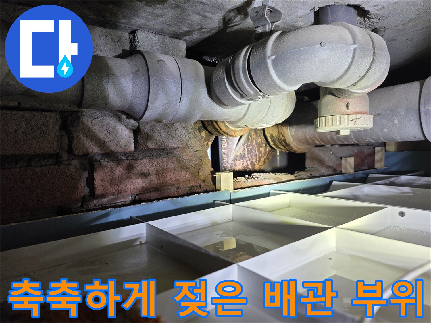 습기로 인해 변색된 천장 배관과 주변 벽돌