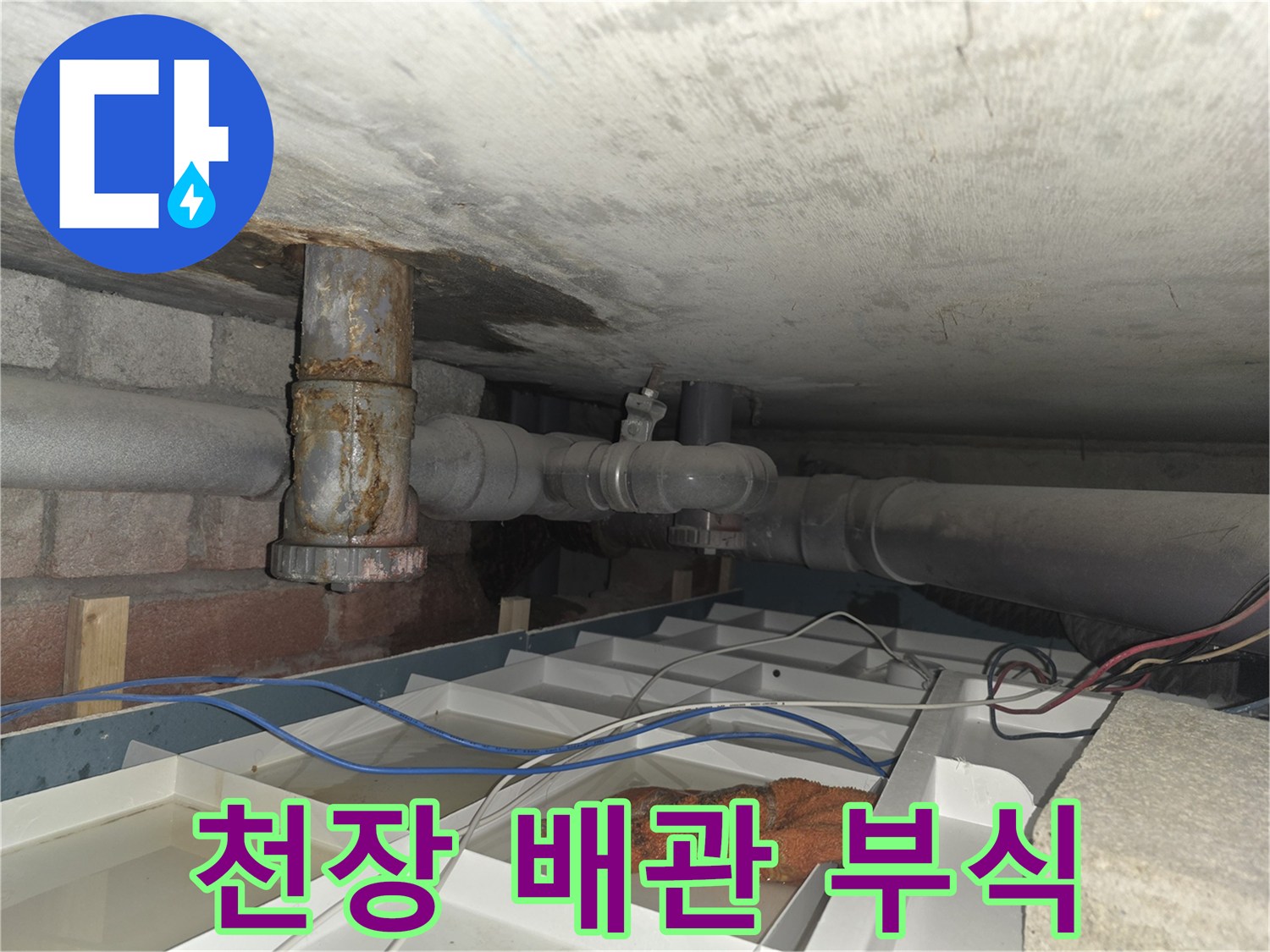 습기와 부식으로 오염된 천장 내부의 배관 연결 구조