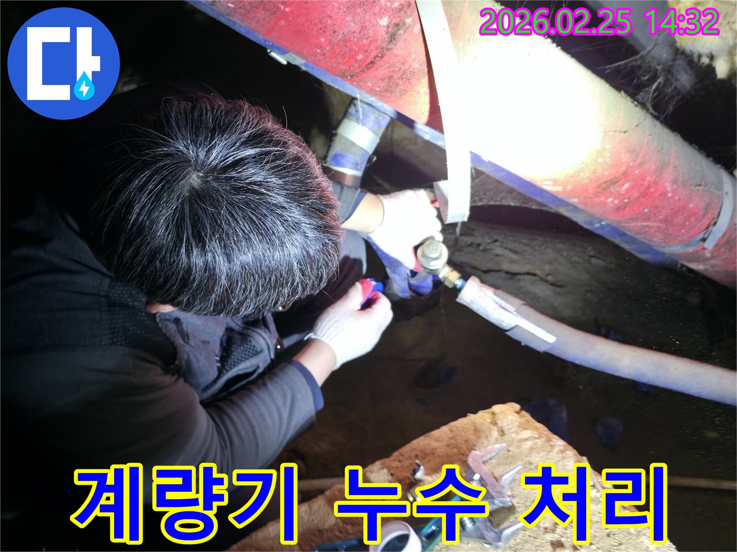 누수 전문 엔지니어가 어두운 공간에서 수도 계량기 주변의 파이프를 정밀하게 점검하고 수리하고 있습니다-계량기누수해결-전문가수리