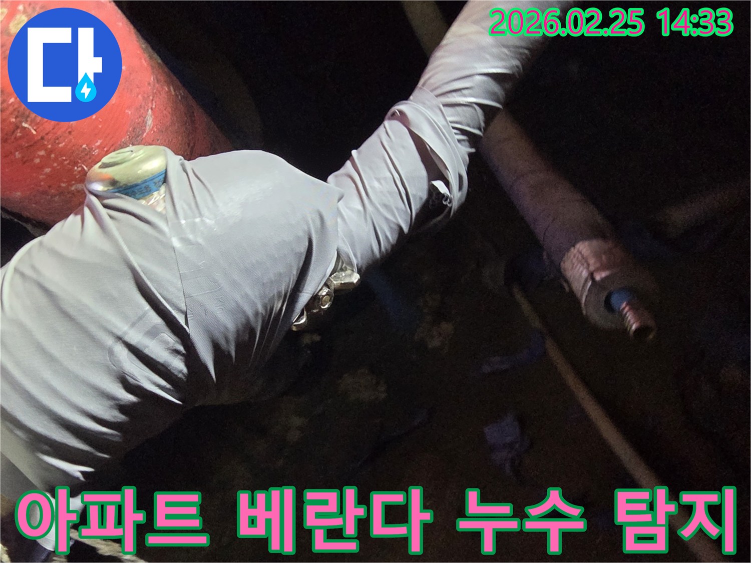 누수-전문가가-아파트-베란다-누수-원인을-찾기 위해-배관에-탐지-장비를-연결하는-사진