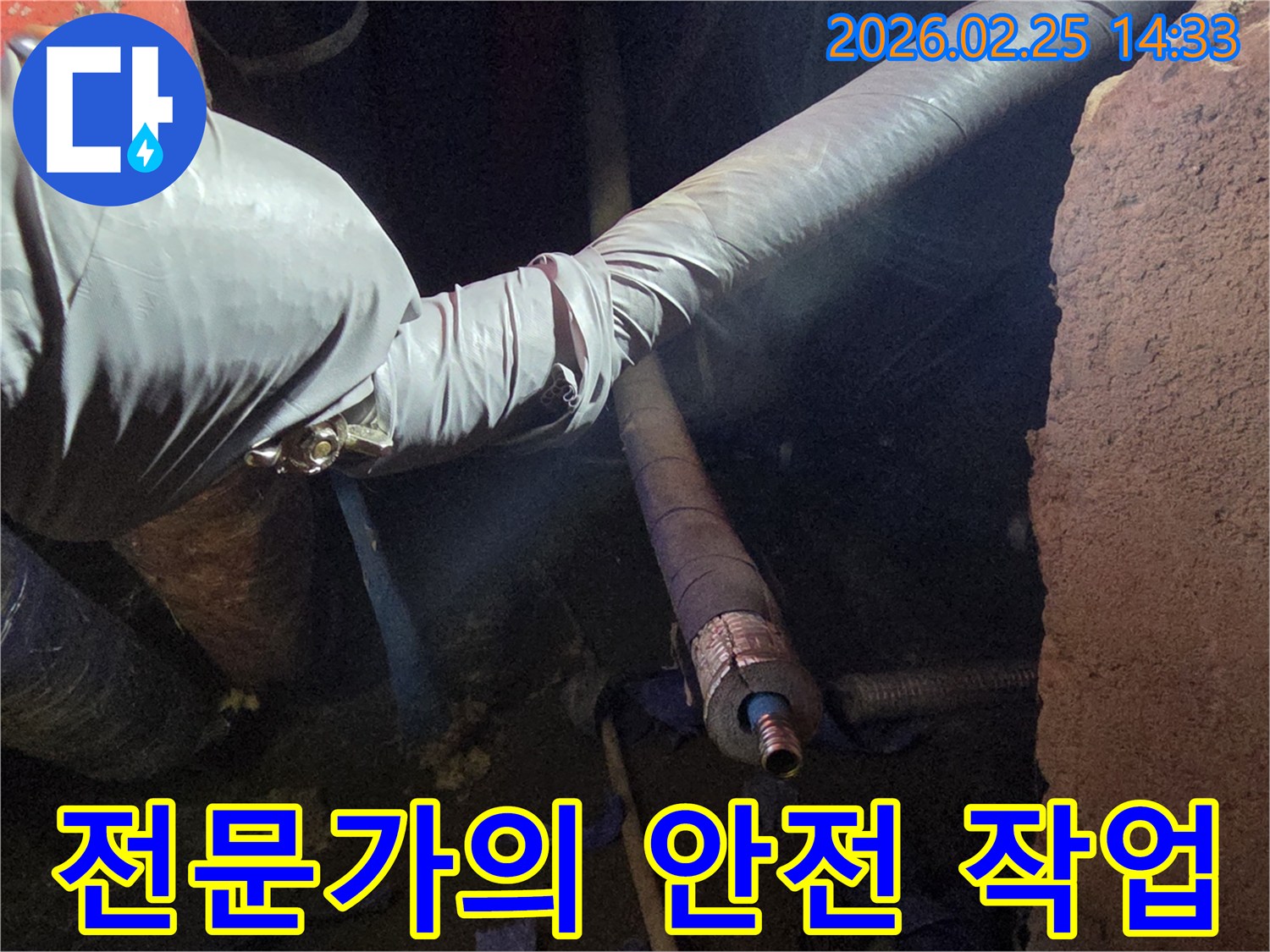 어두운 작업 공간에서-안전 장갑을 낀 손이-배관의 손상 부위를-세심하게 다루며-안전하게 작업을-진행하는 모습입니다