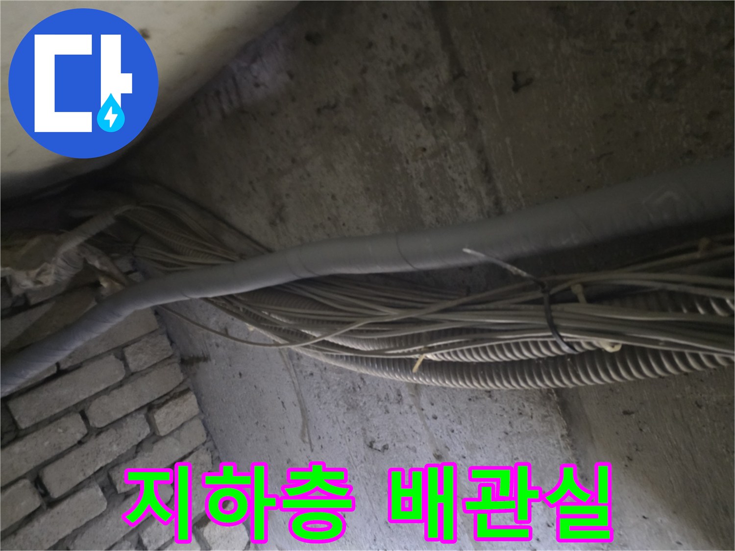 어두운 지하 공간 내부에 설치된 배관 및 전선관