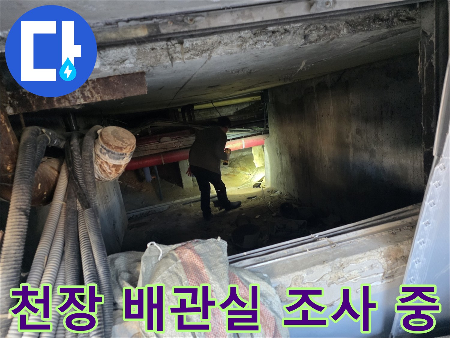 어두운 지하 배관 공간에서 배관 상태를 점검하는 엔지니어의 모습